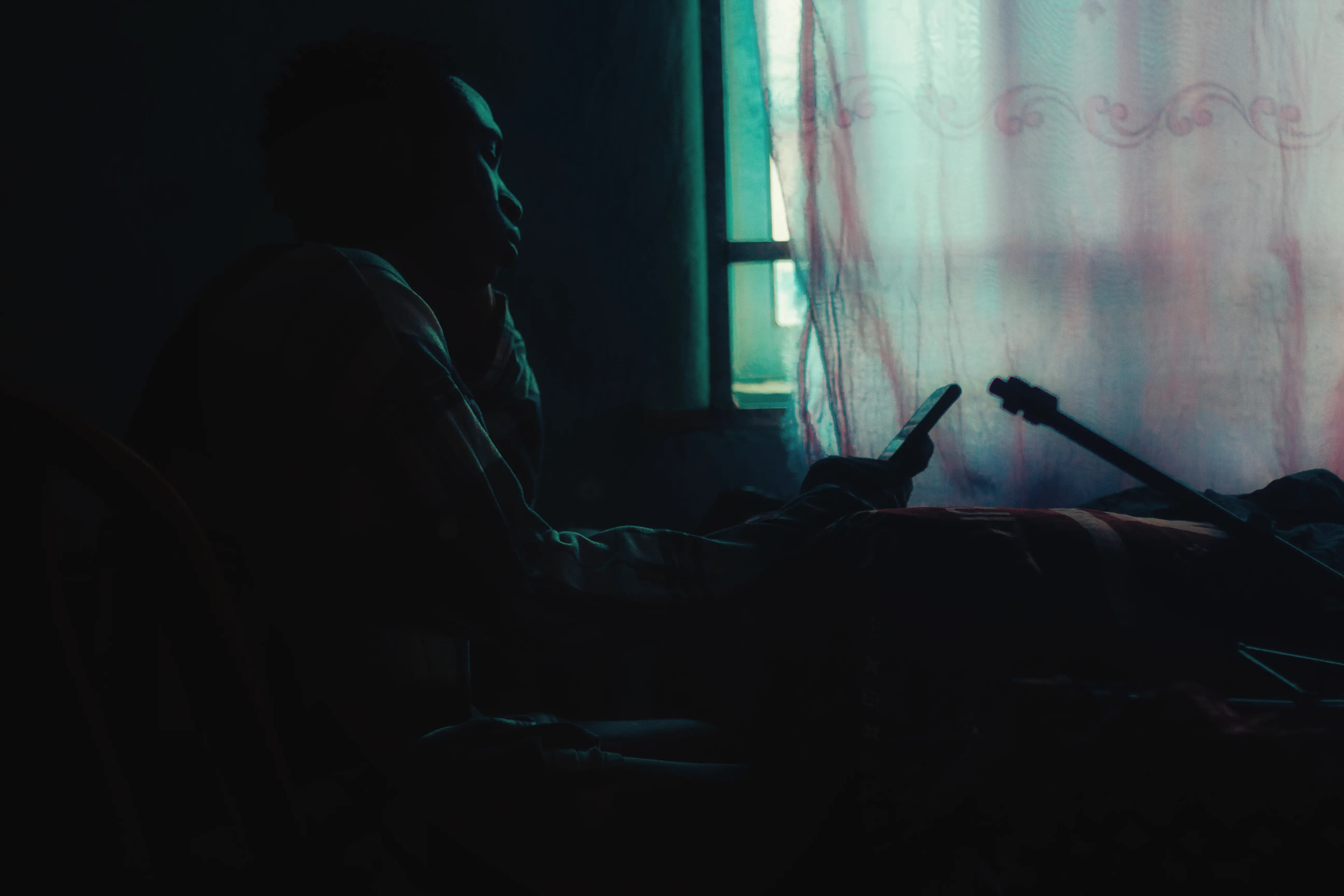 Anonymous figure in quiet contemplation beside a sunlit window
