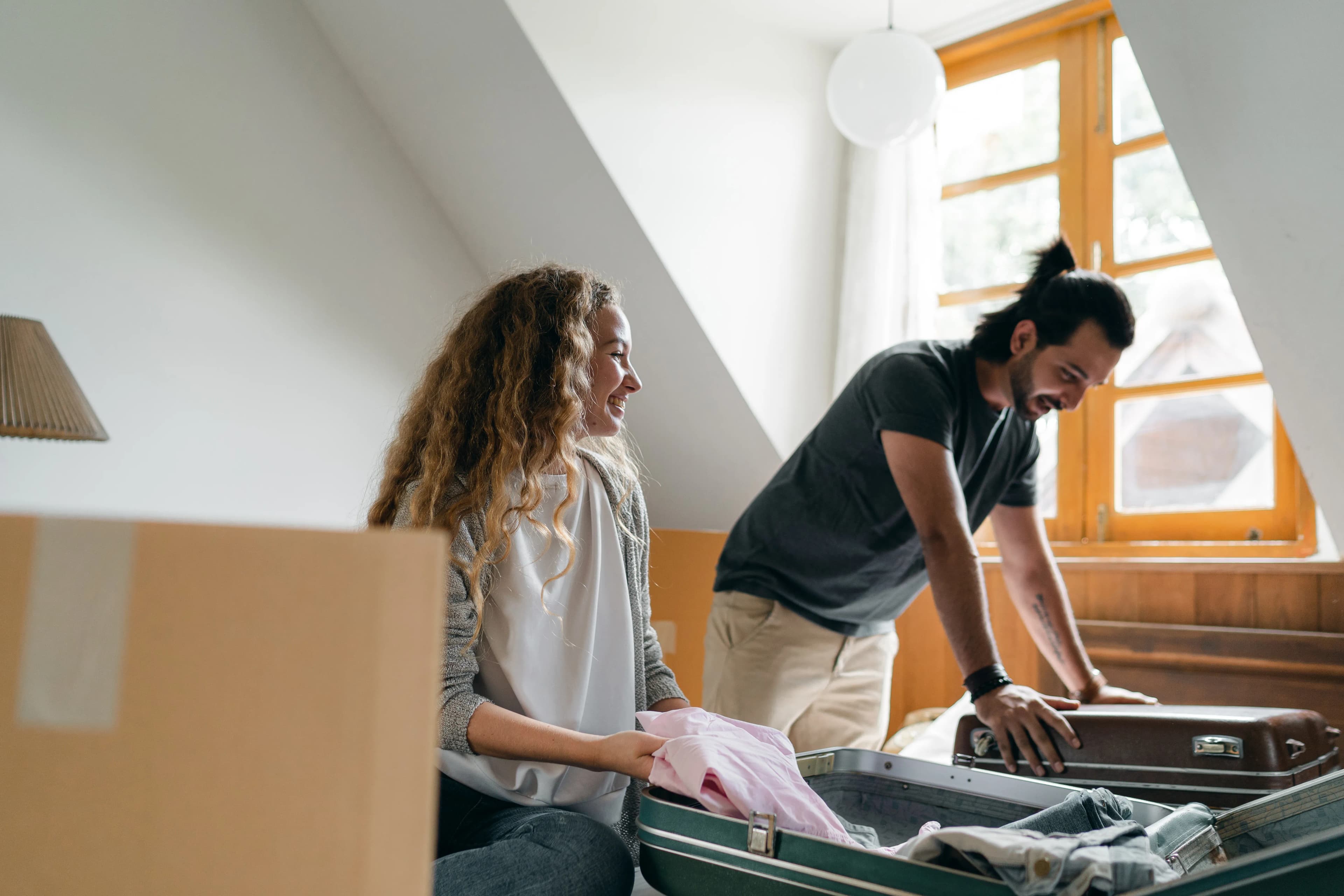 Two people packing belongings together before a move