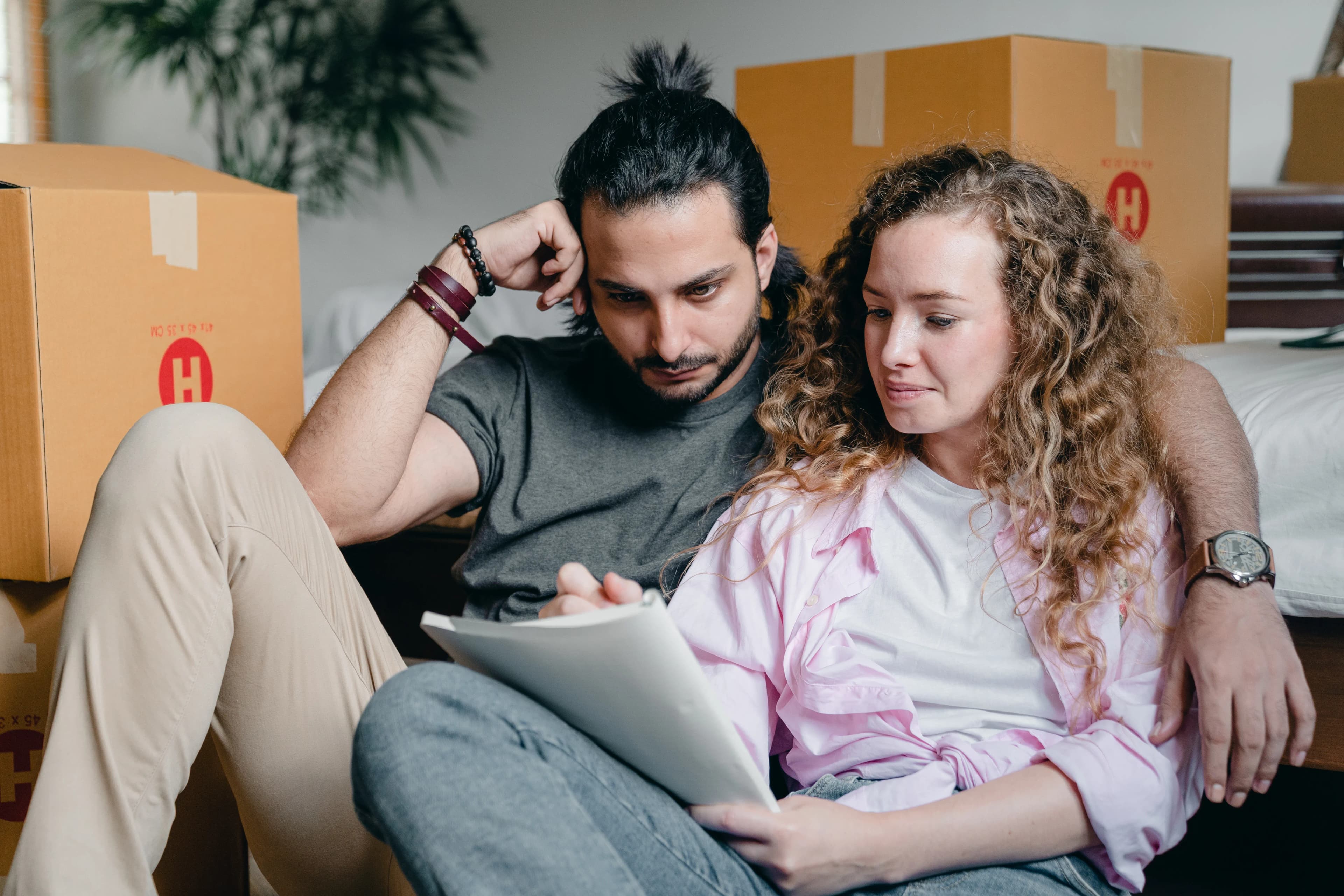 Two partners checking plans together among moving boxes