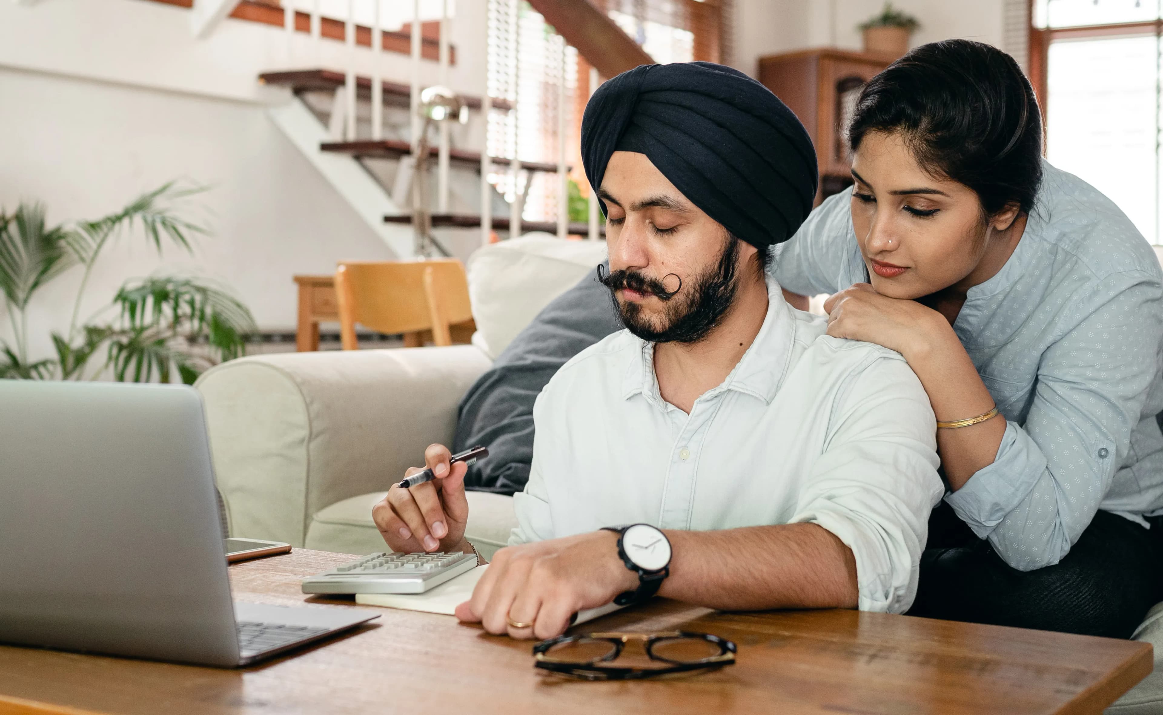Couple working together on a household budget with a calculator