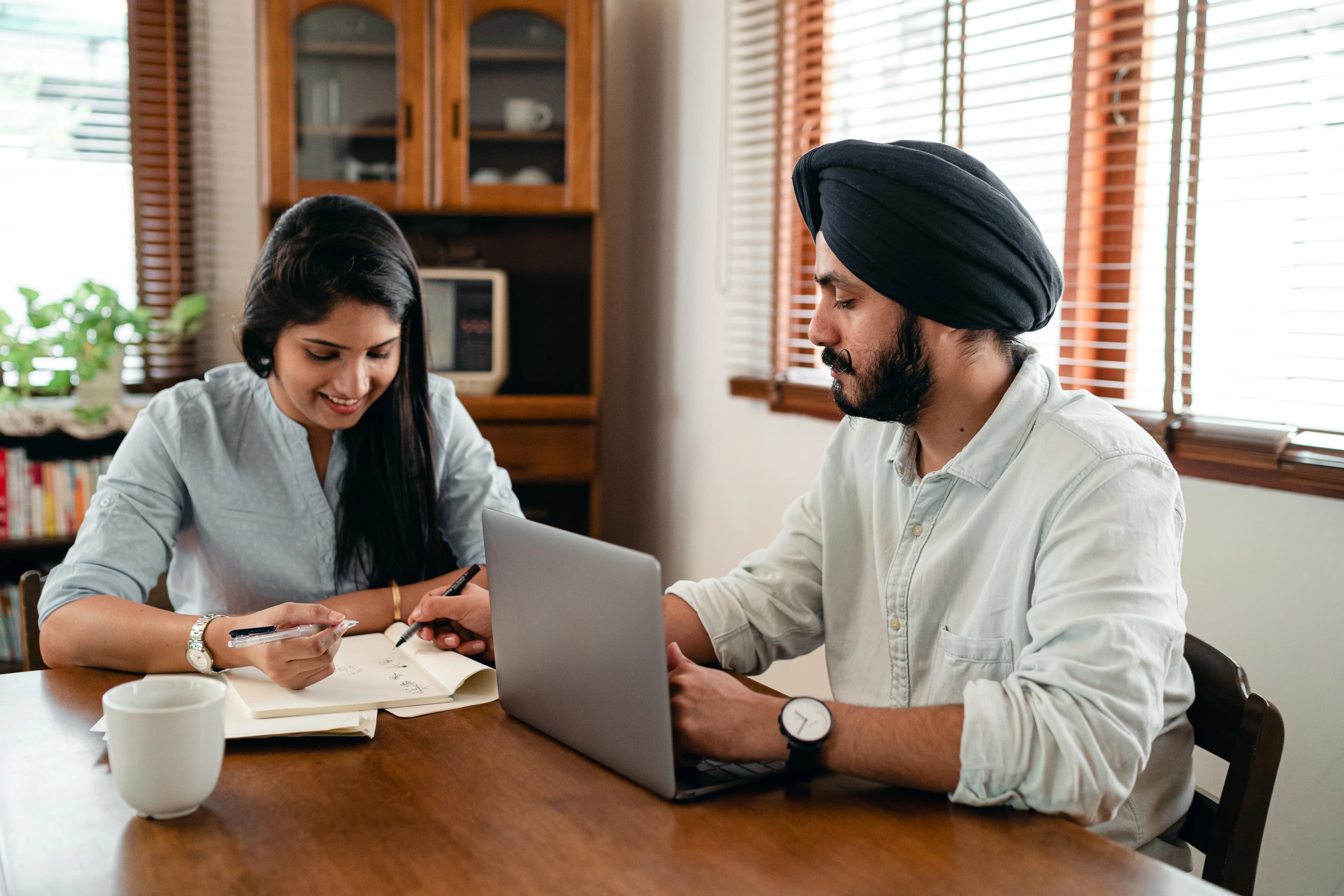 Two partners collaborating around a laptop and notes at home