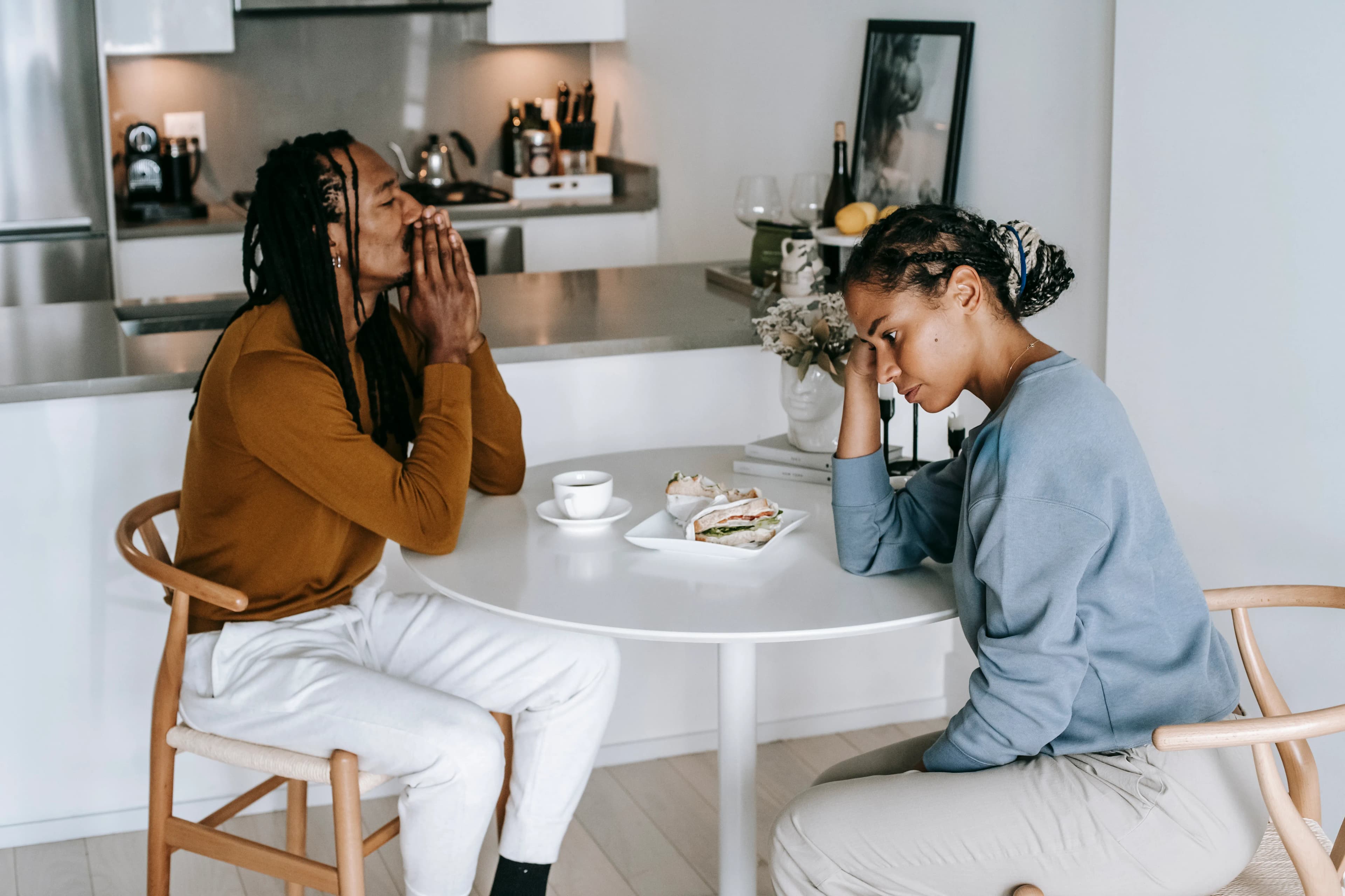 Two partners engaged in a serious discussion across a kitchen table