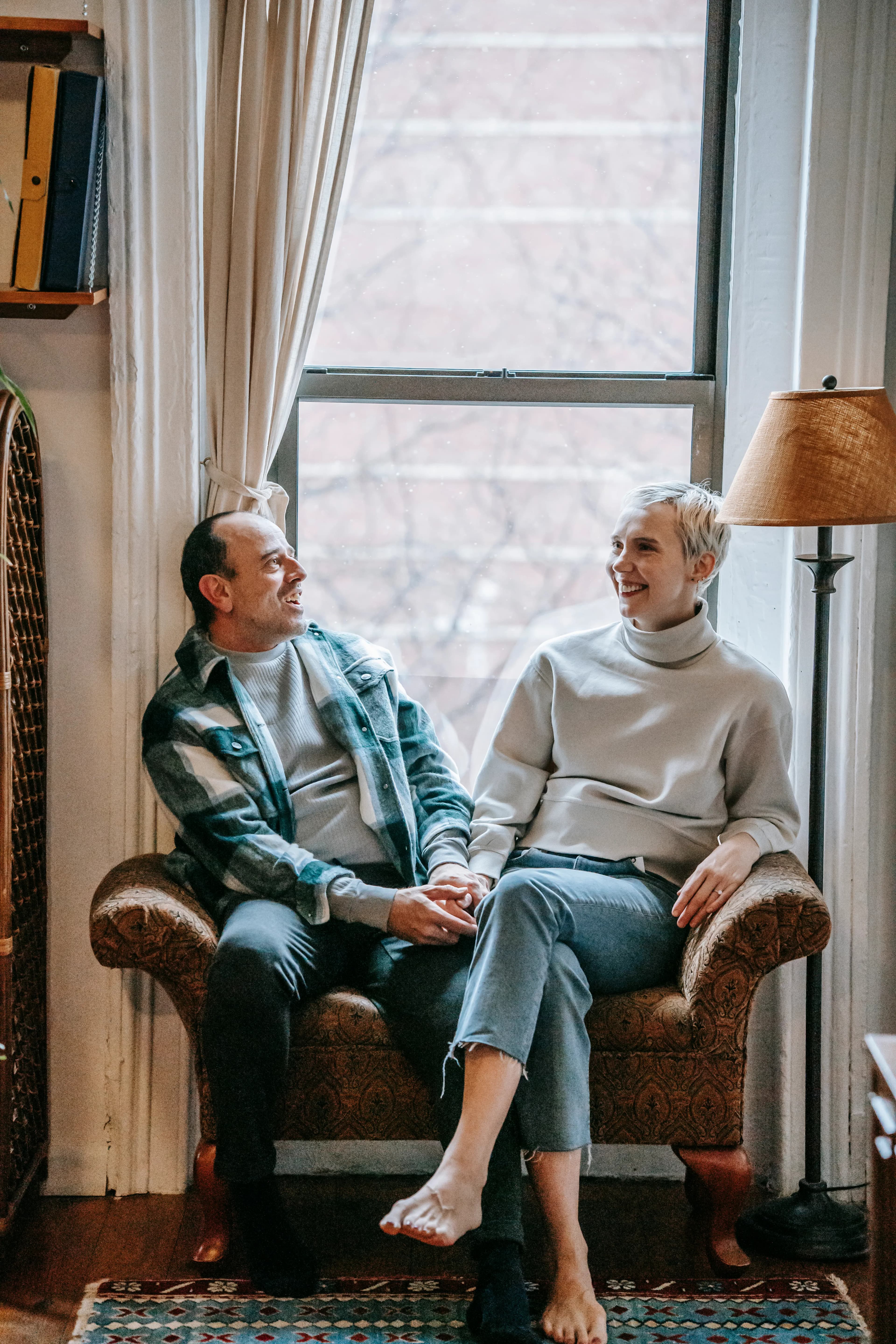 Middle-aged couple enjoying conversation near a window