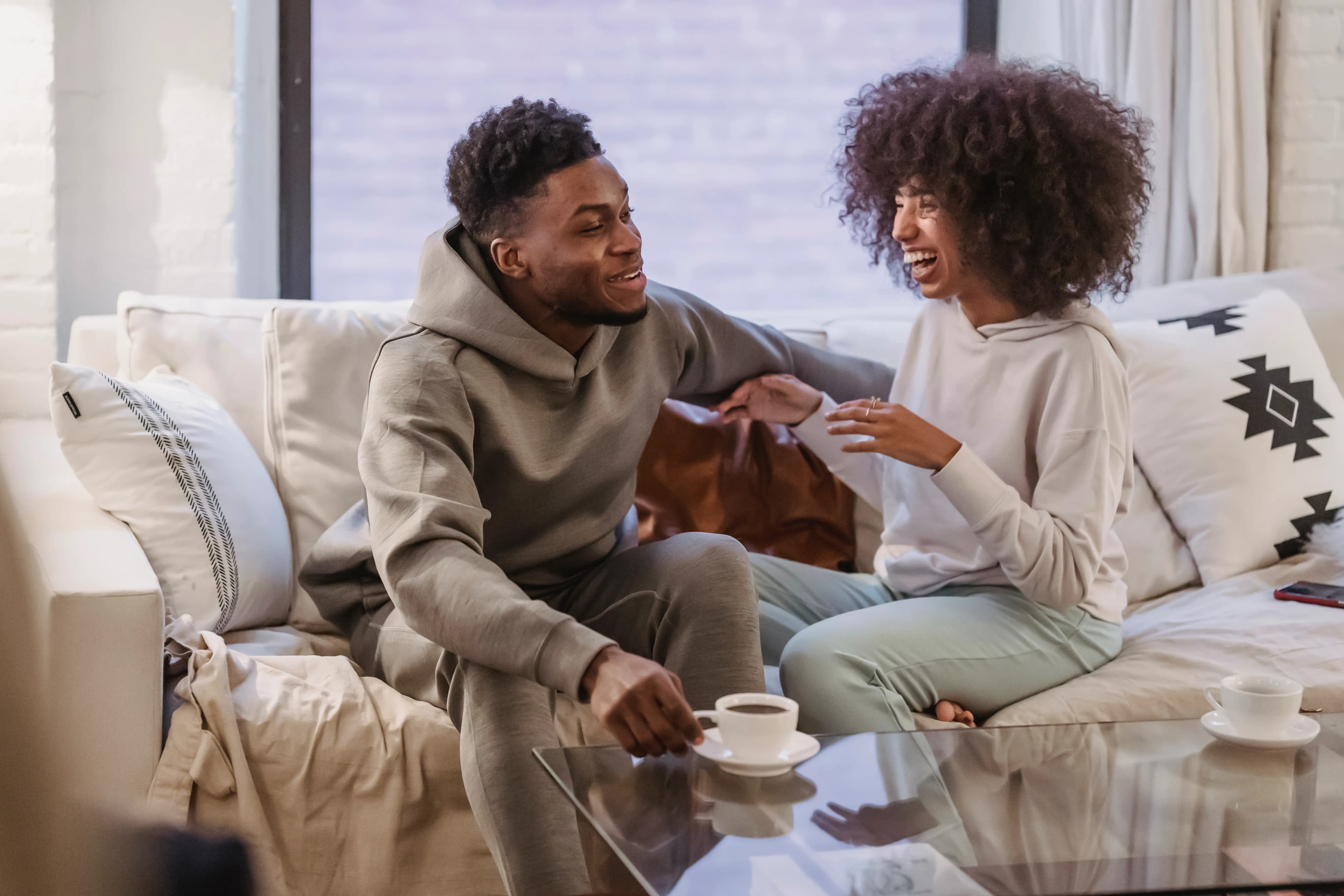 Couple smiling and talking together in a comfortable home