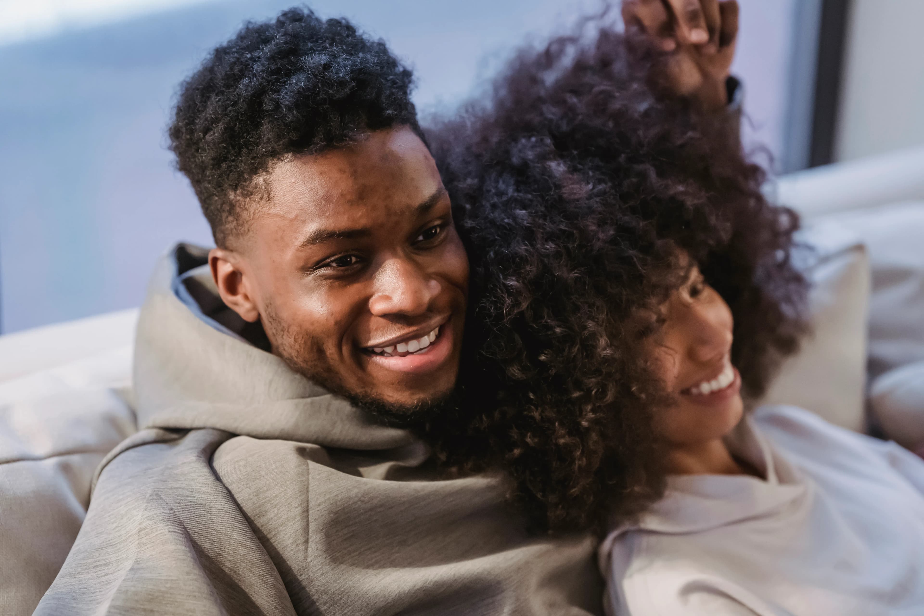 Couple relaxing side by side and smiling in a sunlit room