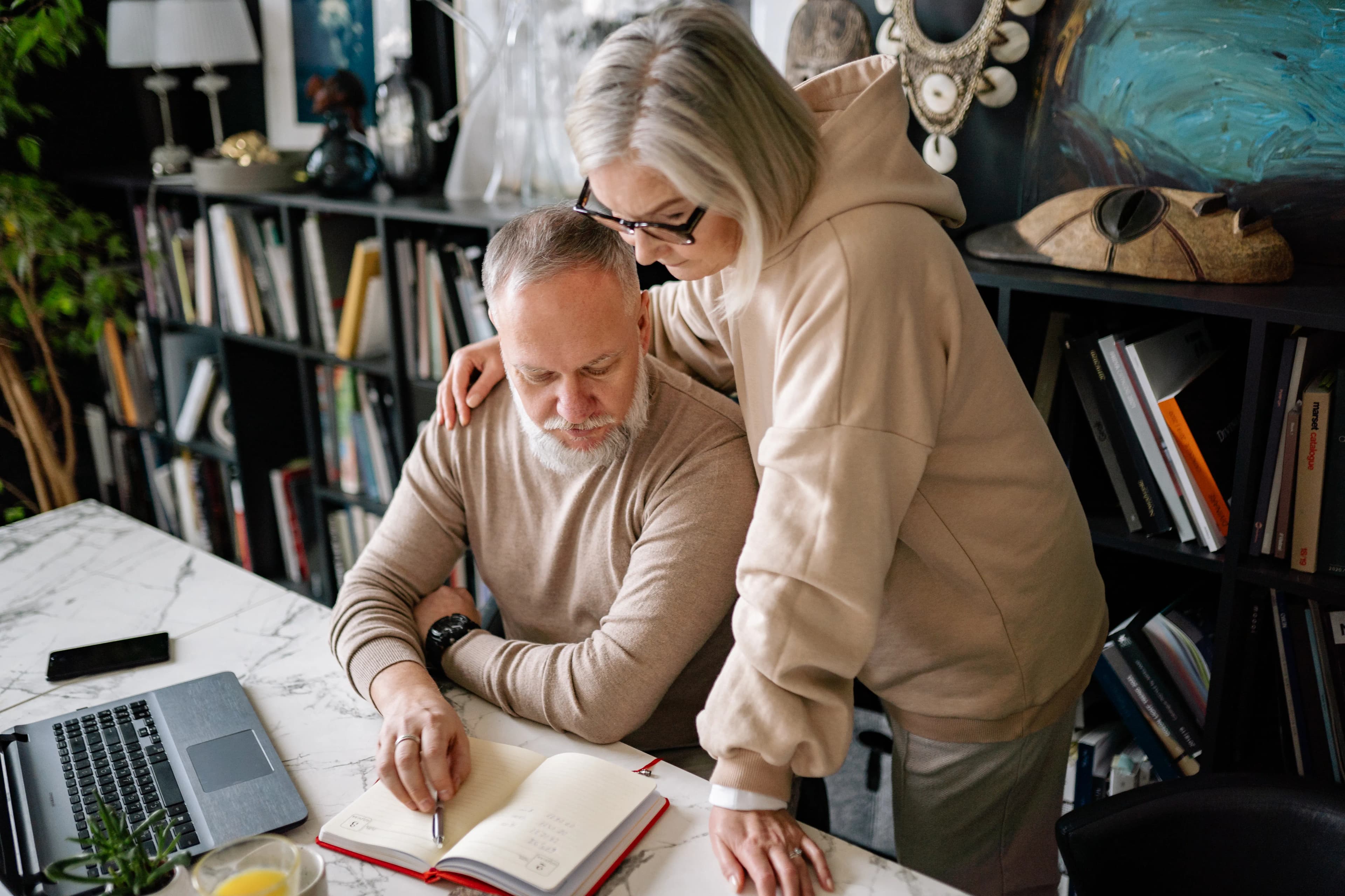Older couple reviewing notes and plans together at a desk