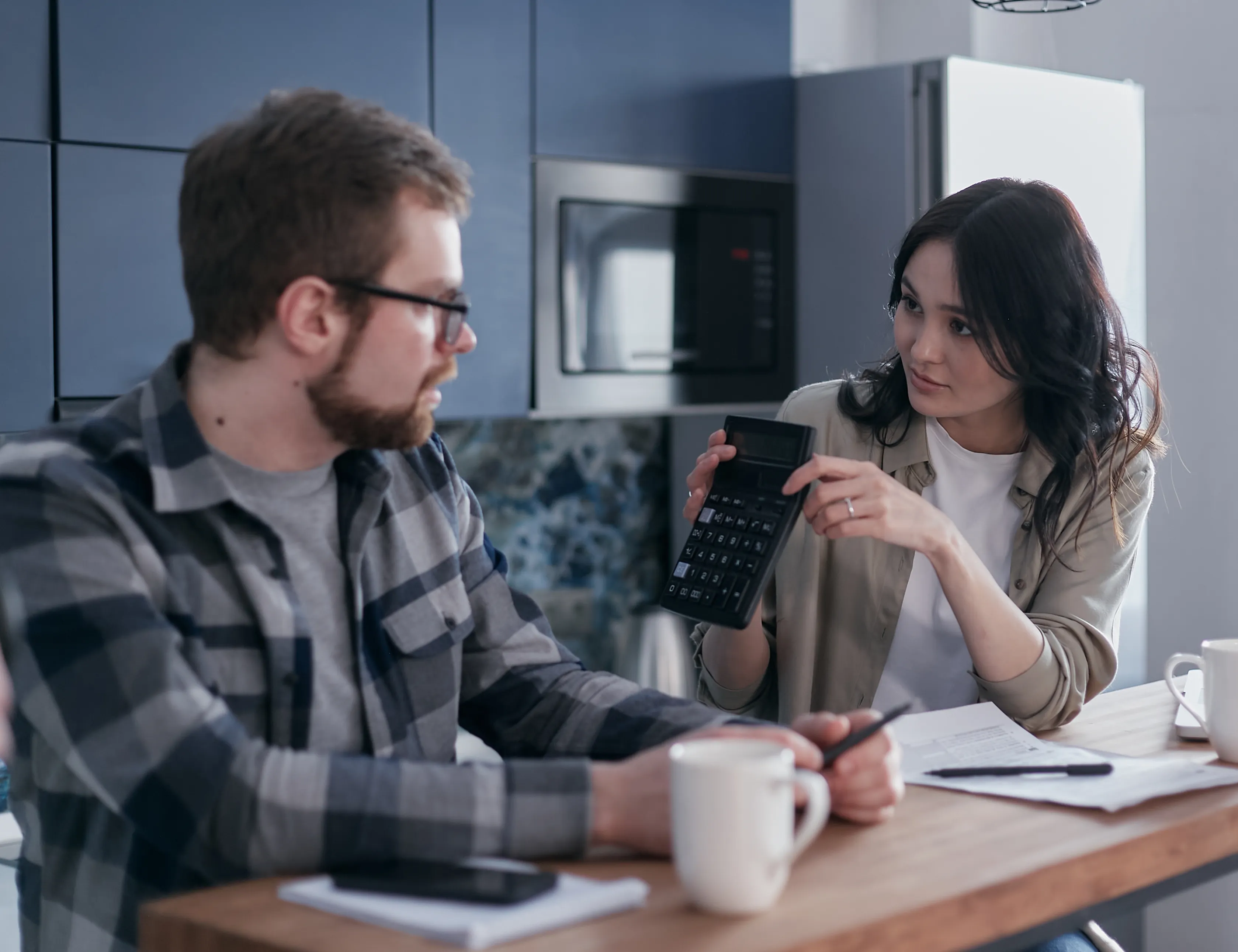 Two partners reflecting over bills and a calculator