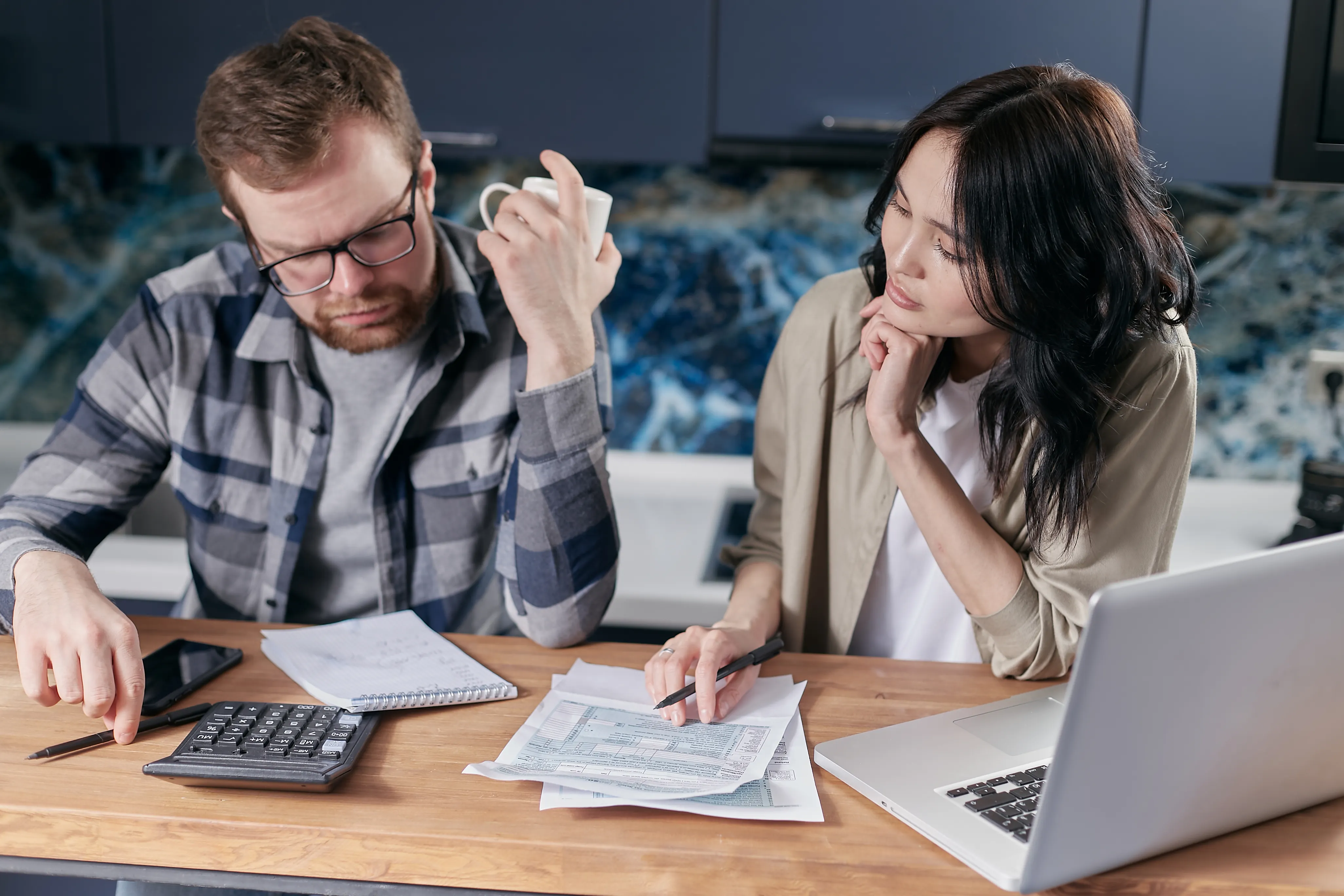 Two partners reviewing household finances together at a table