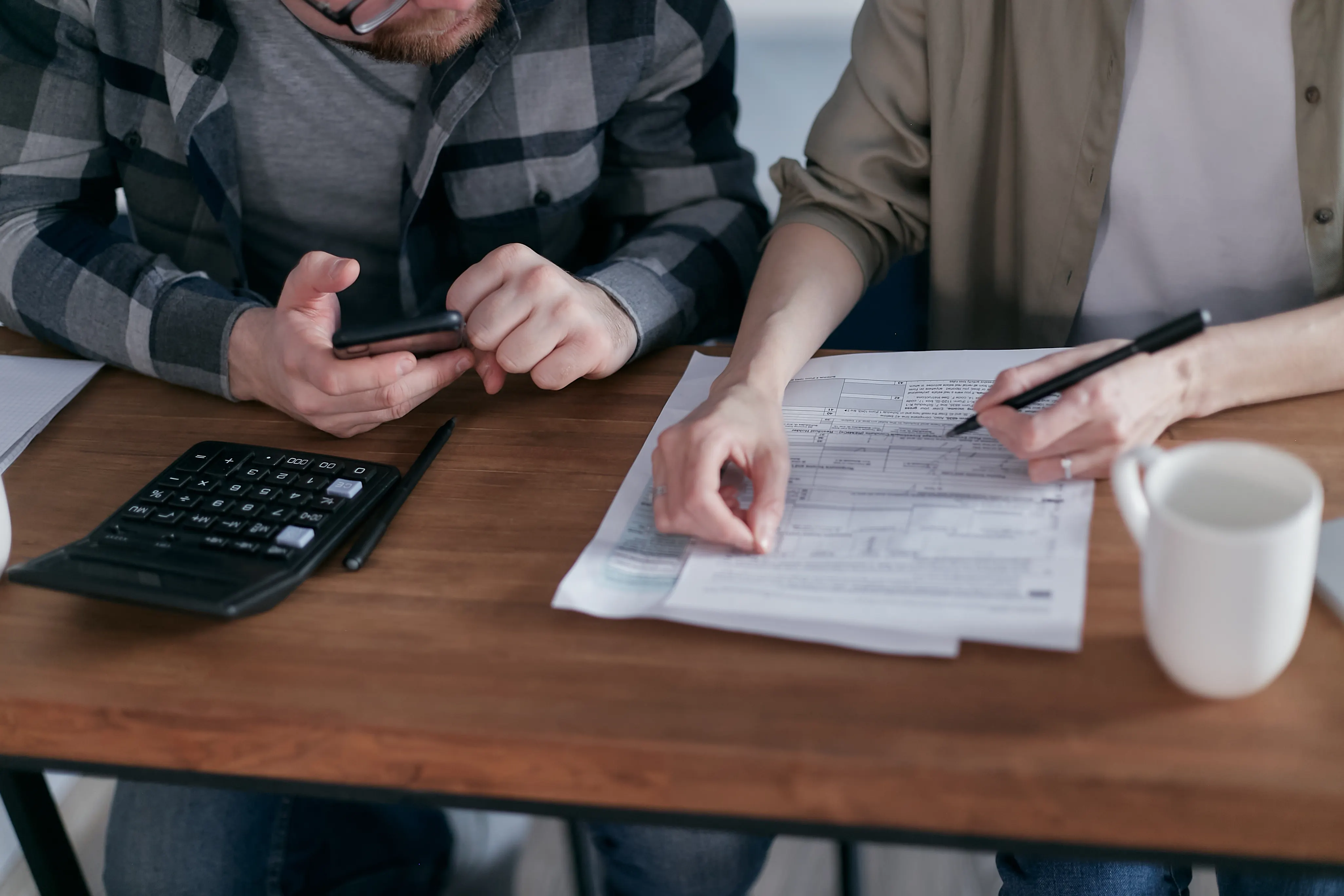 Two people examining financial paperwork together at home