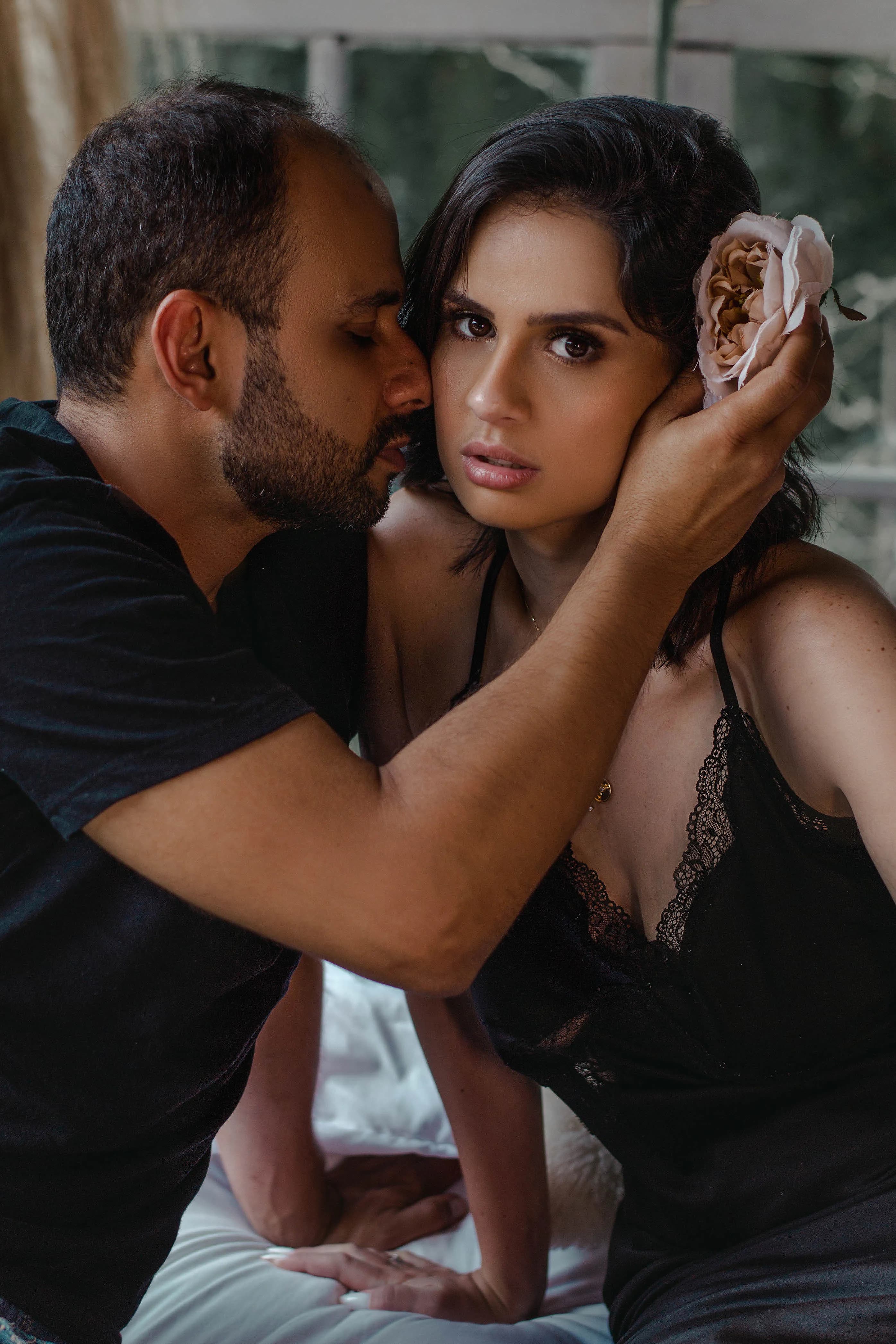 Couple embracing in an intimate portrait by a window
