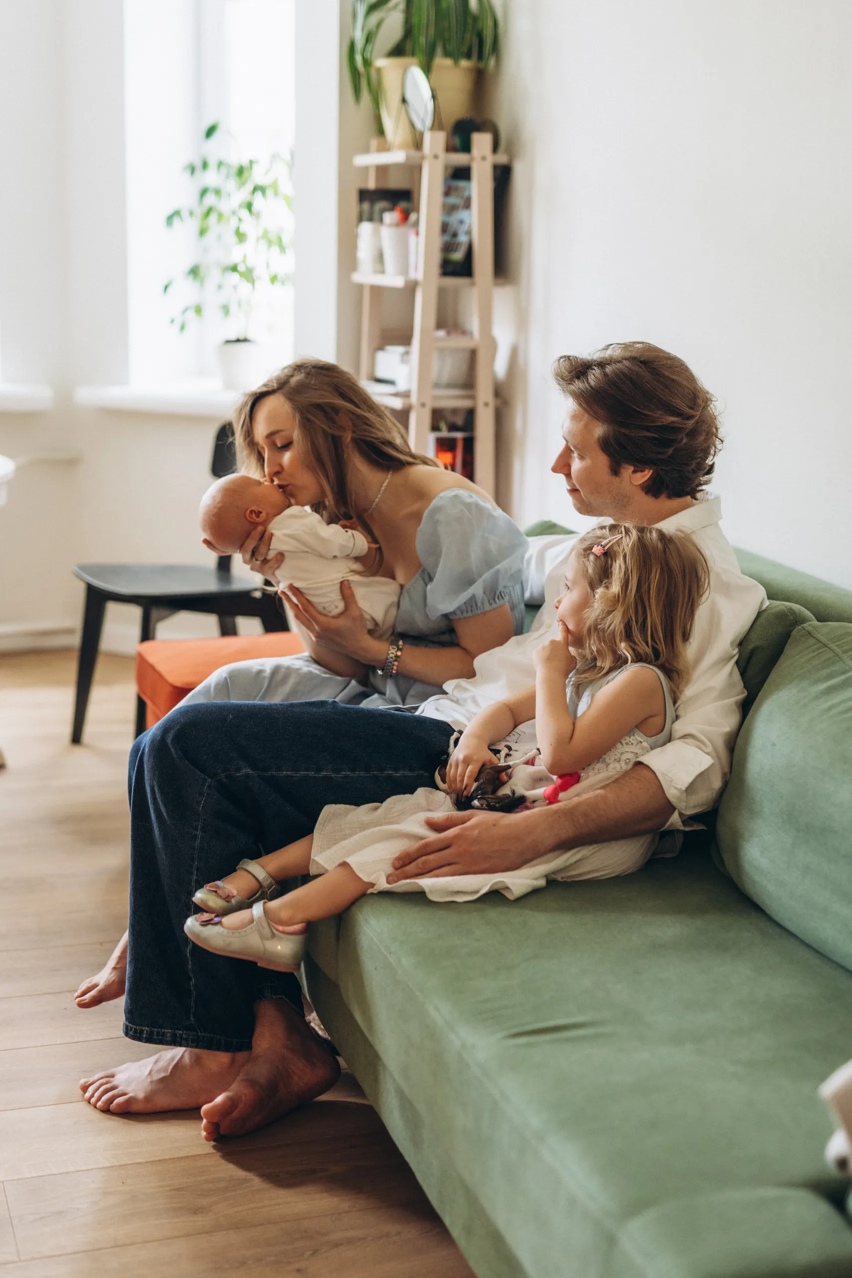 Parents with their children sitting together on a green couch