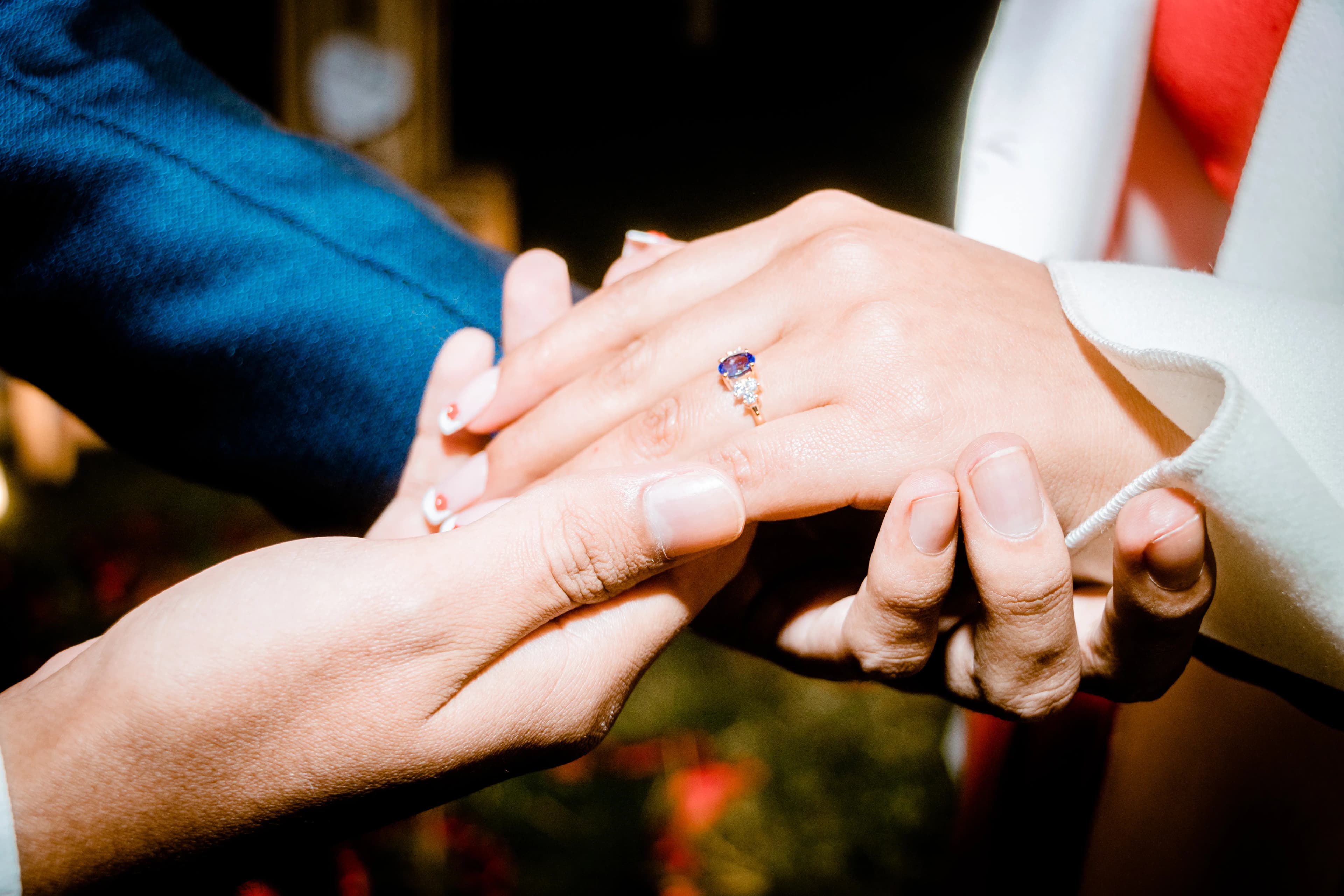 Close-up of hands during a proposal with a diamond ring