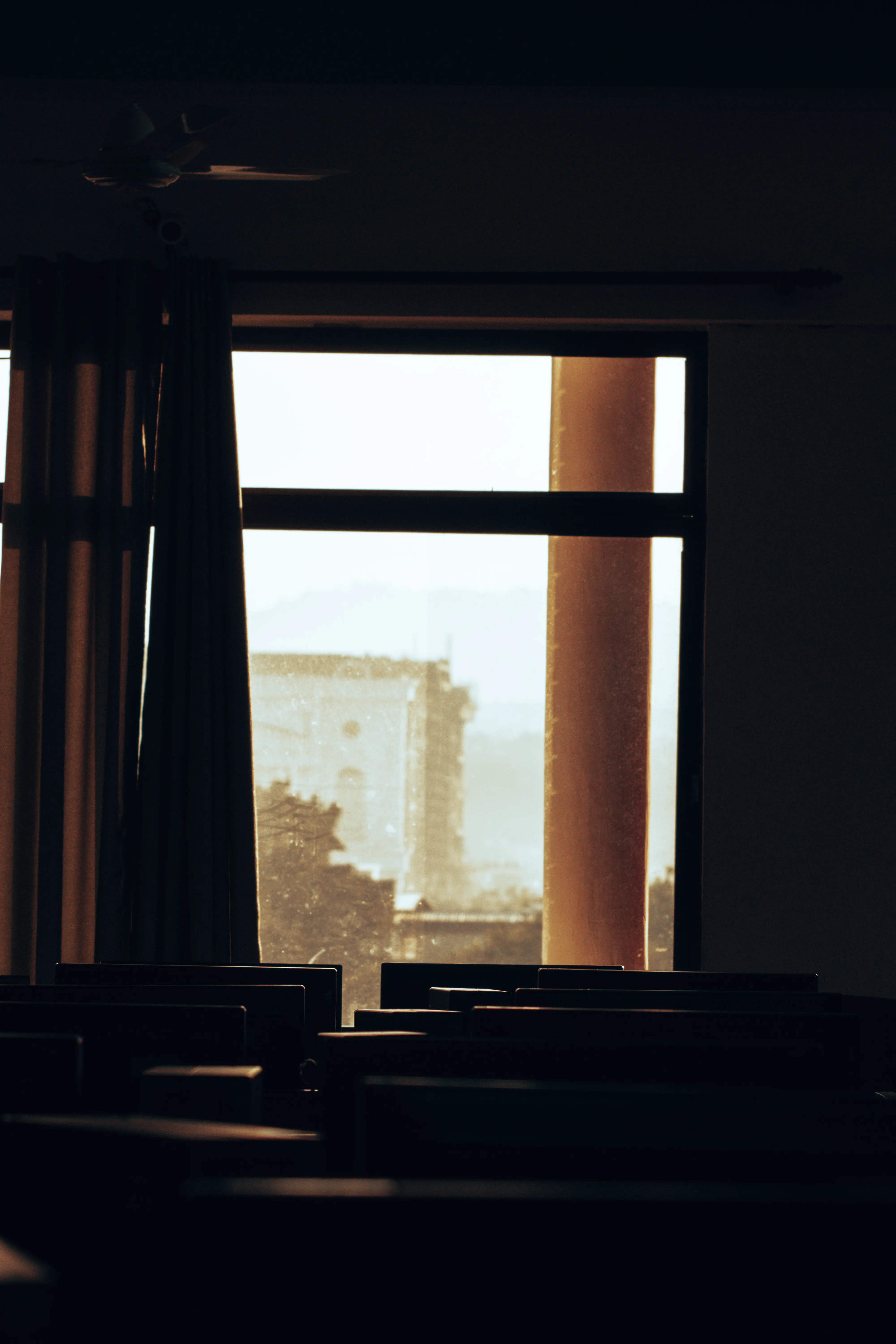 Empty chairs facing a softly lit window in a quiet room
