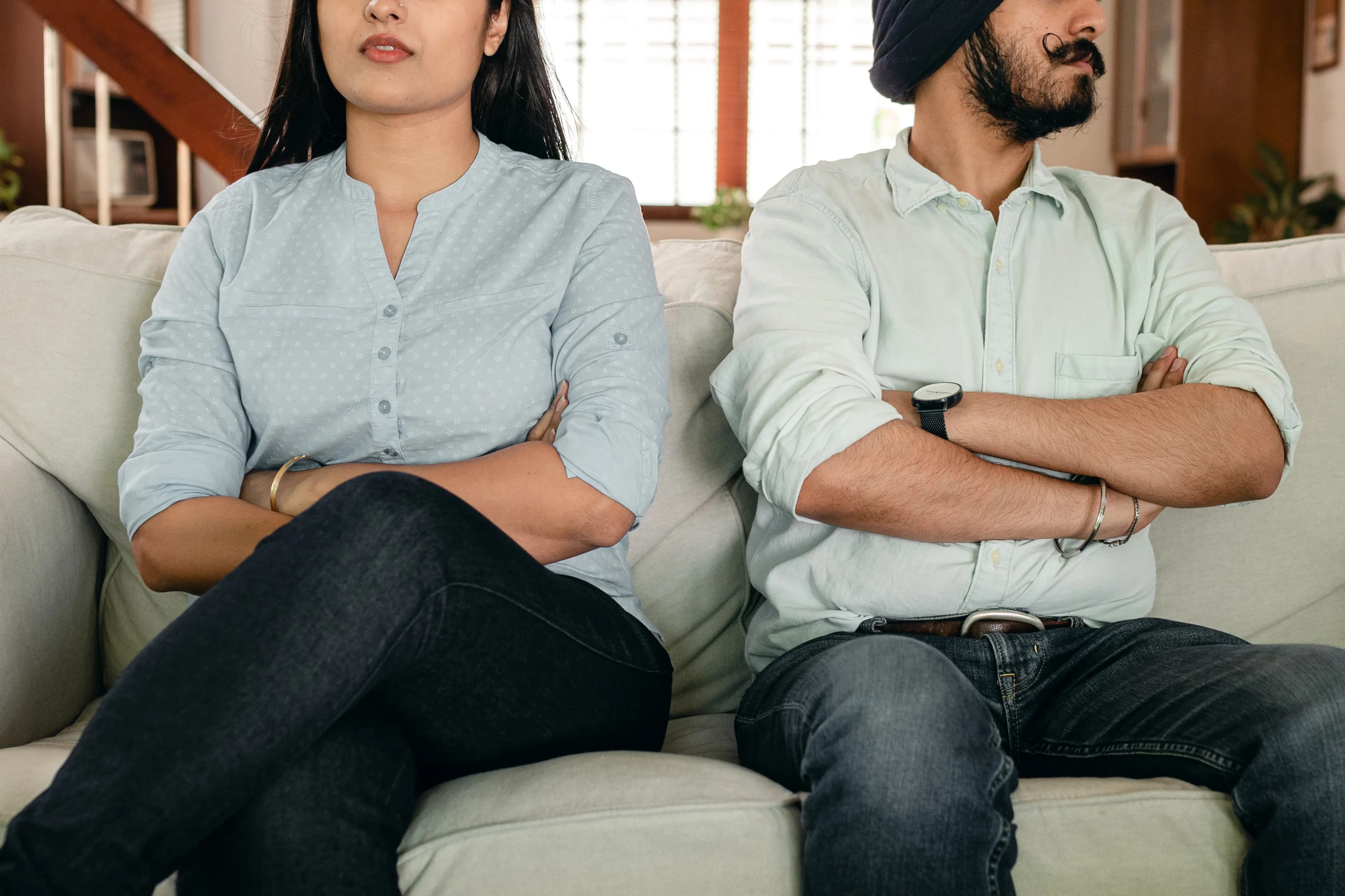 Close crop of a couple sitting with their arms folded