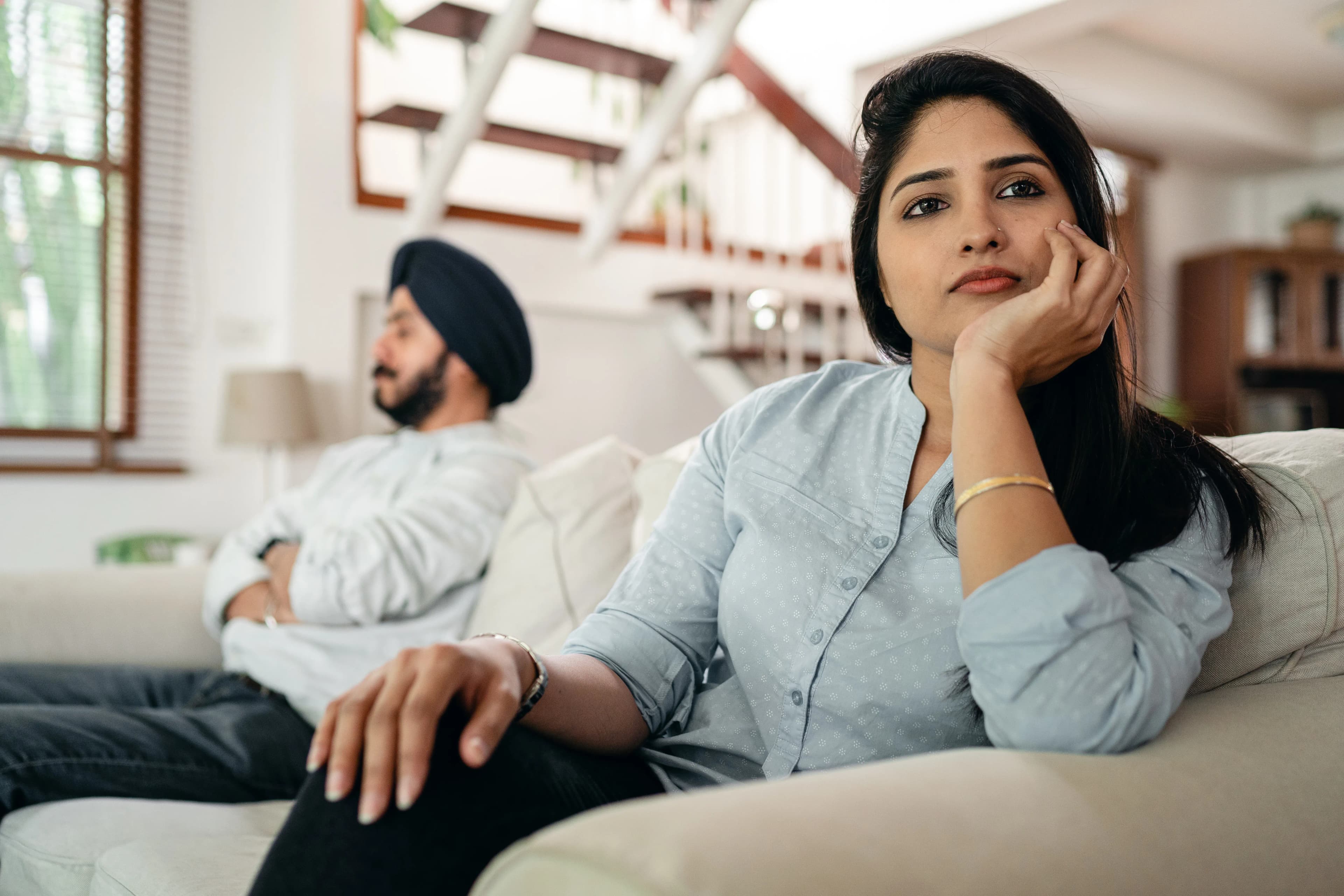 Two partners seated apart in a quiet living room