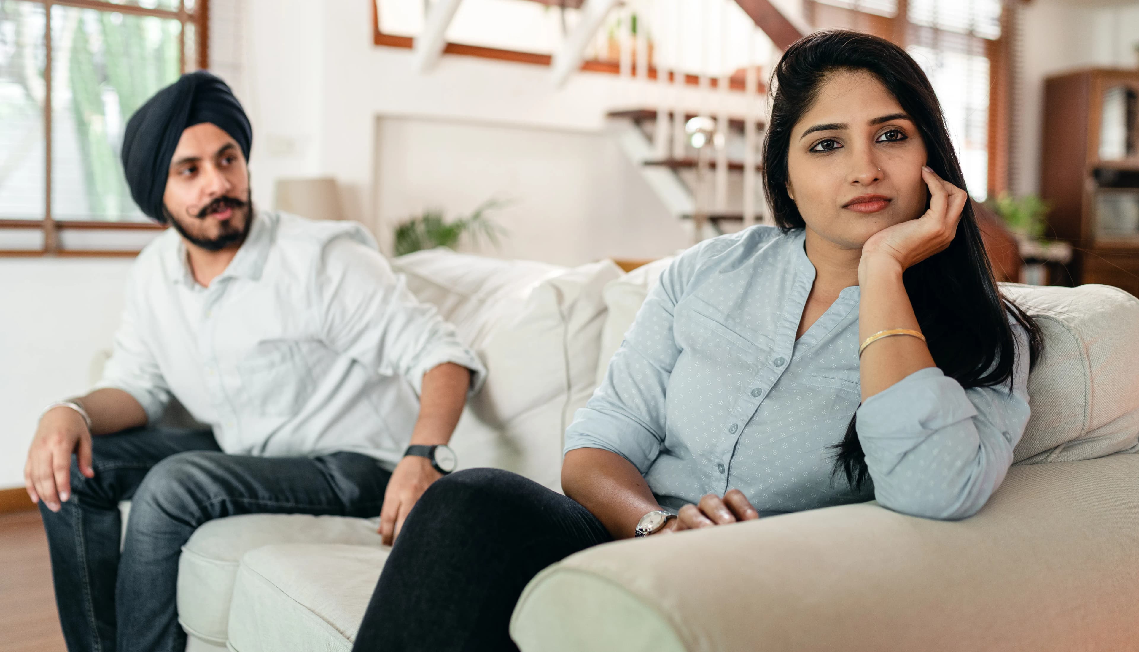 One partner listening while the other attempts to talk on a sofa