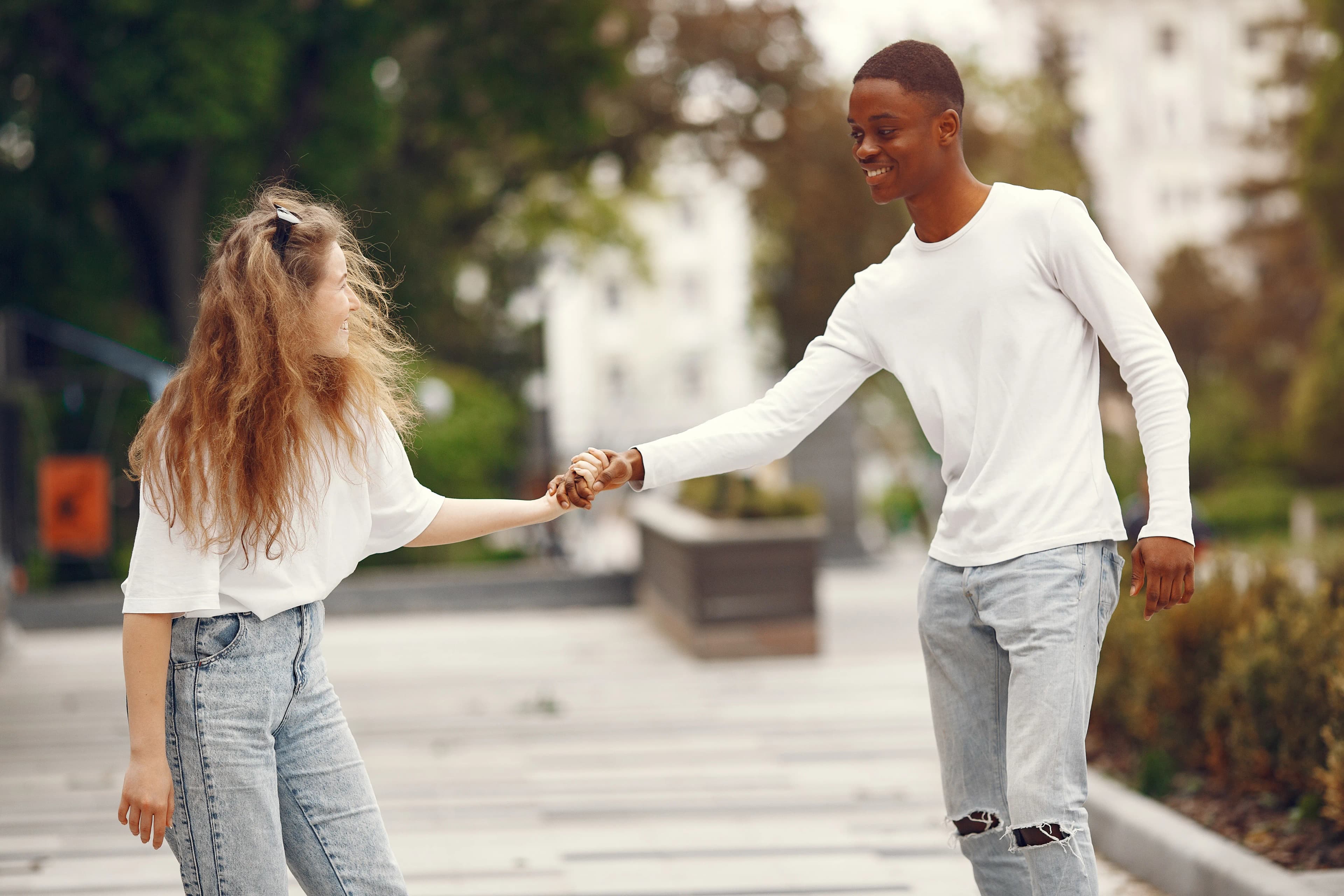 Multiracial couple walking outdoors together hand in hand