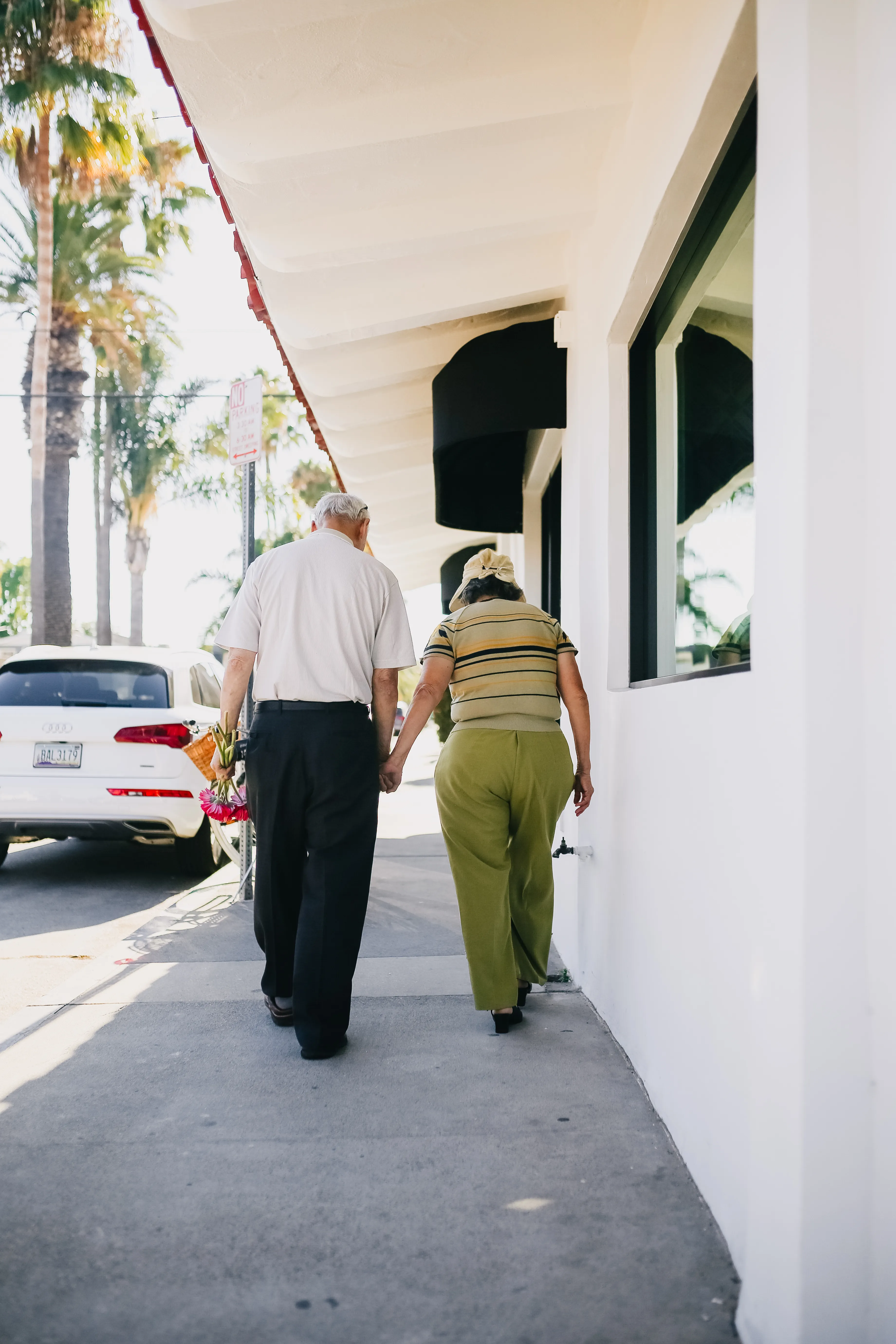 Older couple walking together hand in hand outdoors