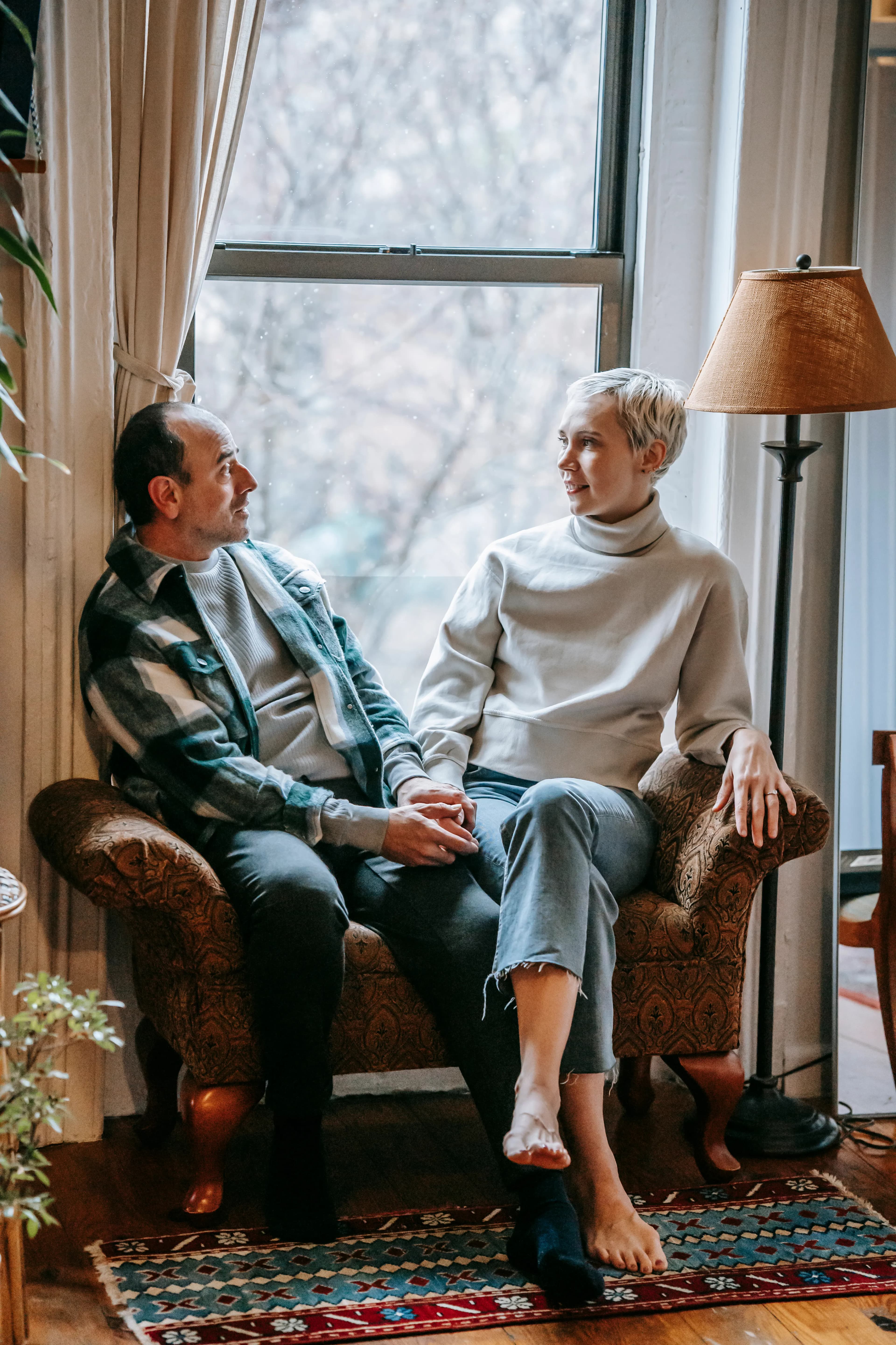 Middle-aged couple sitting closely together in a home lounge