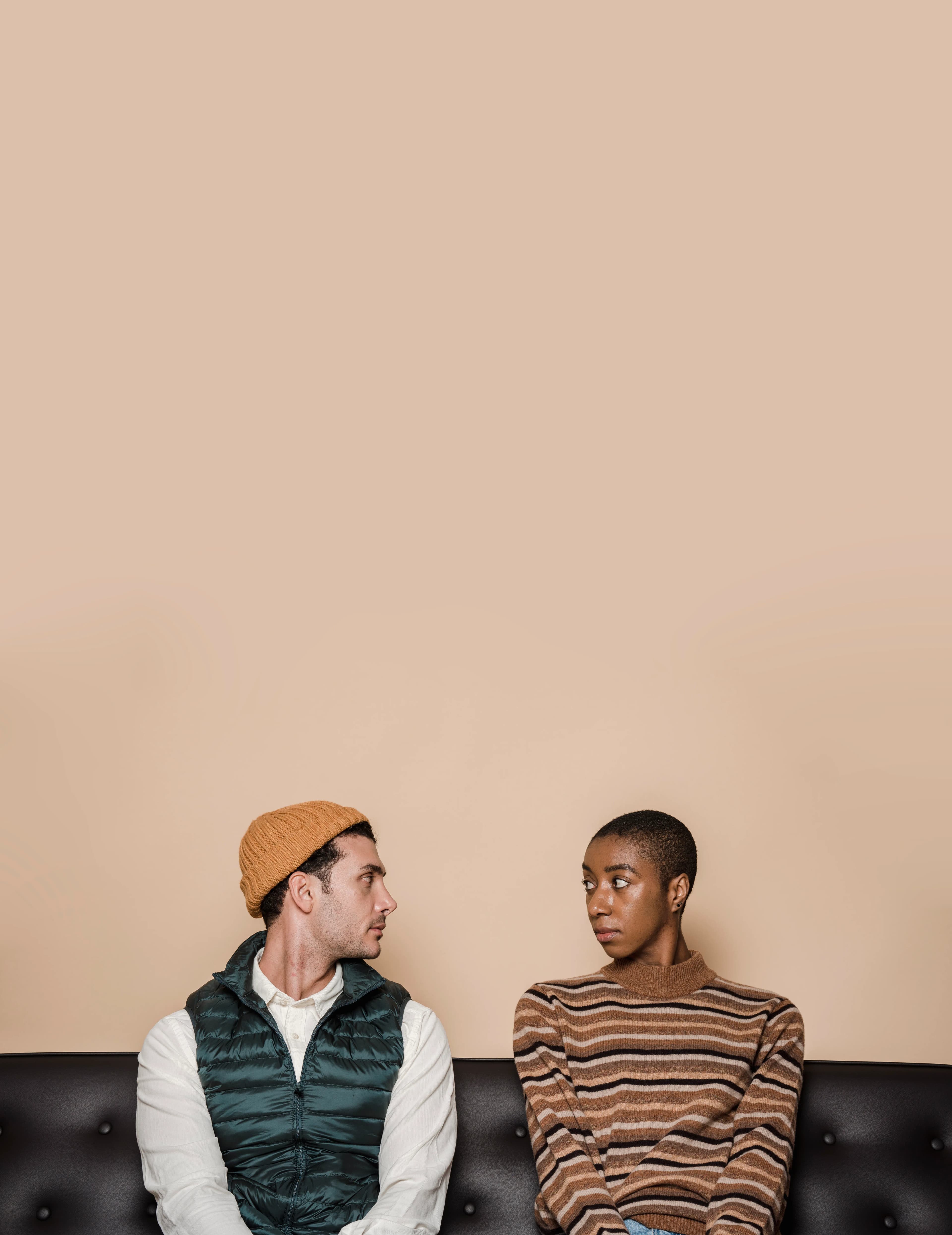 A diverse couple reflecting together while seated on a sofa