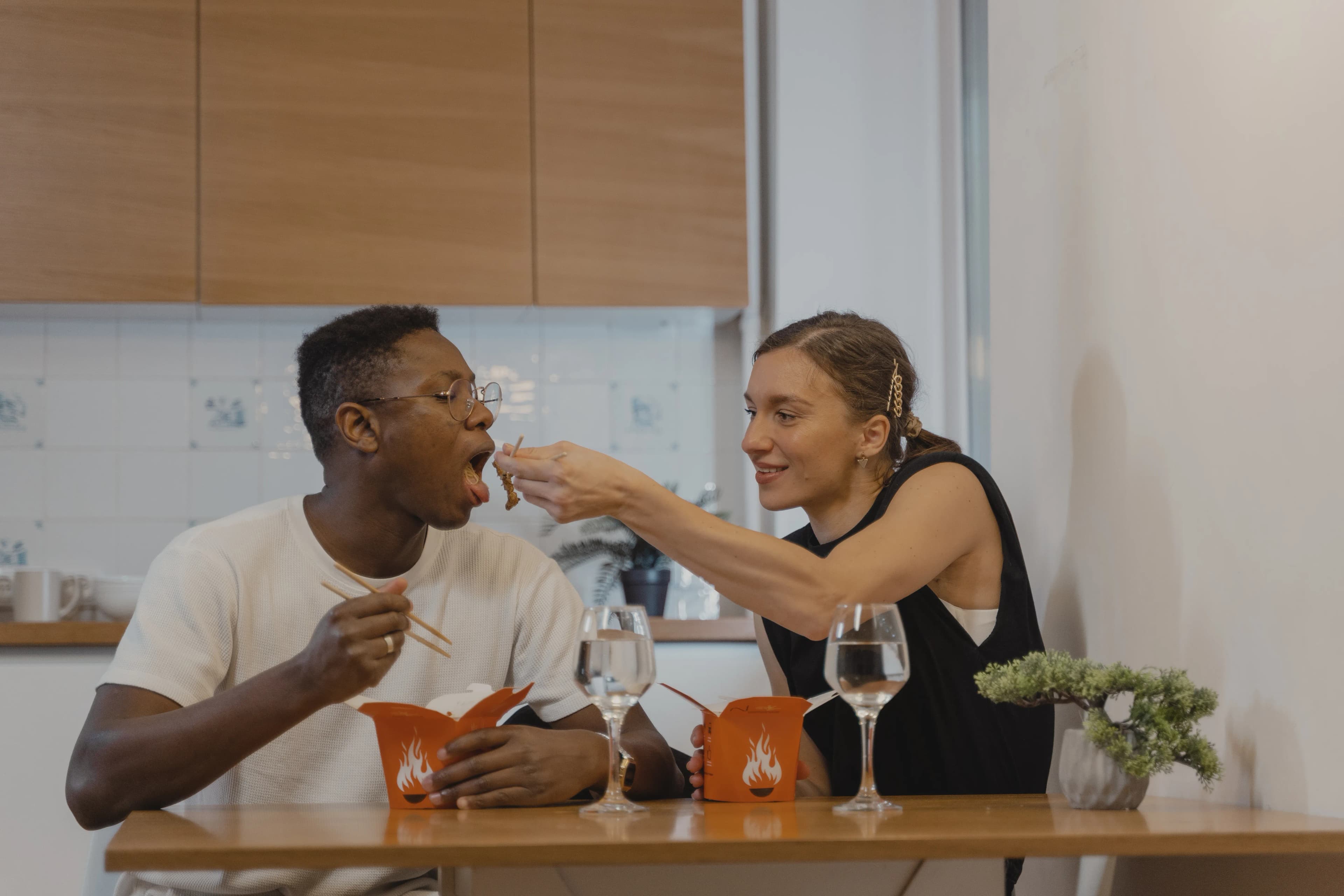 Interracial couple sharing a casual meal and conversation at home