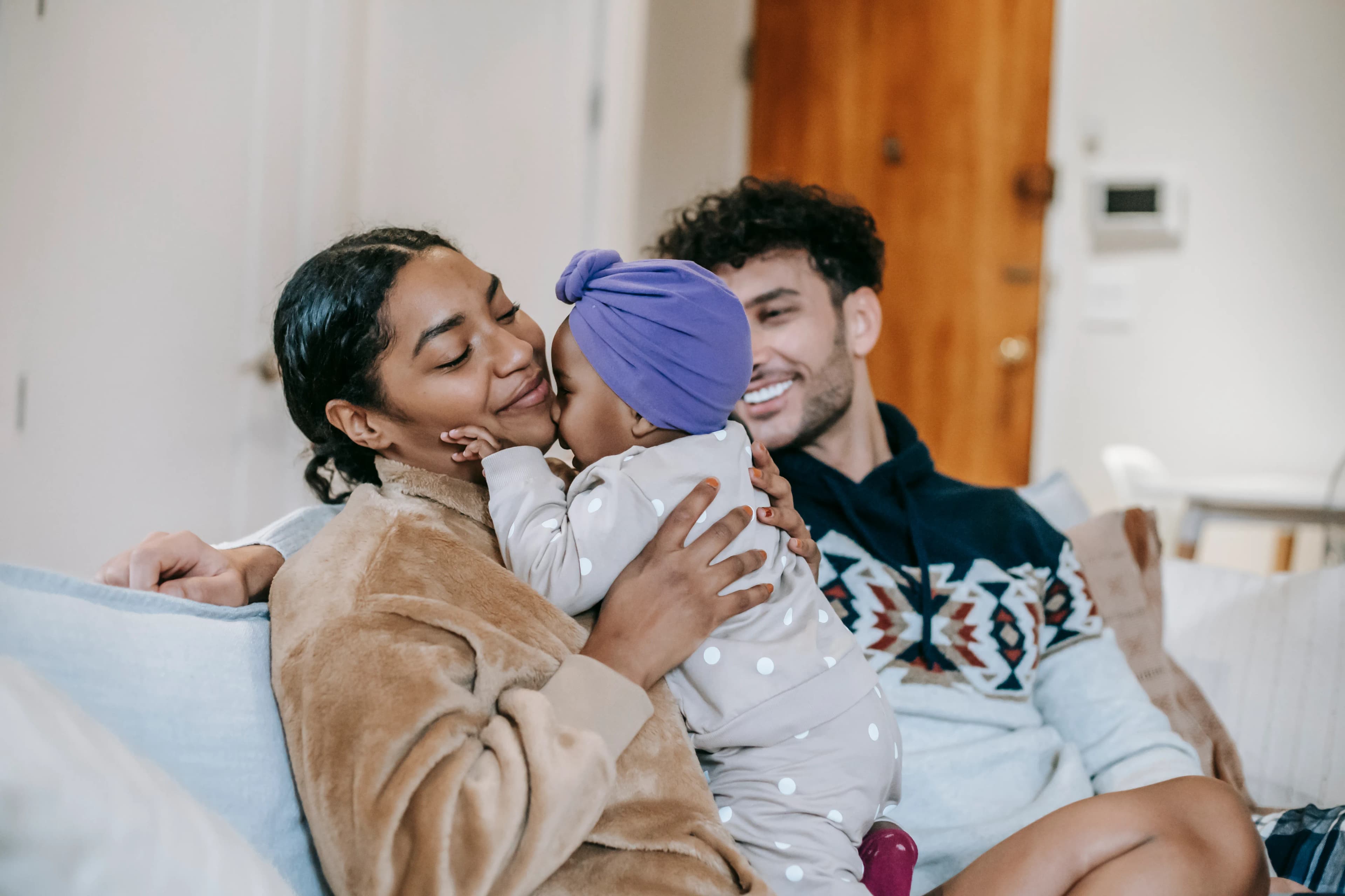 Parents spending time with their young child on the living room sofa