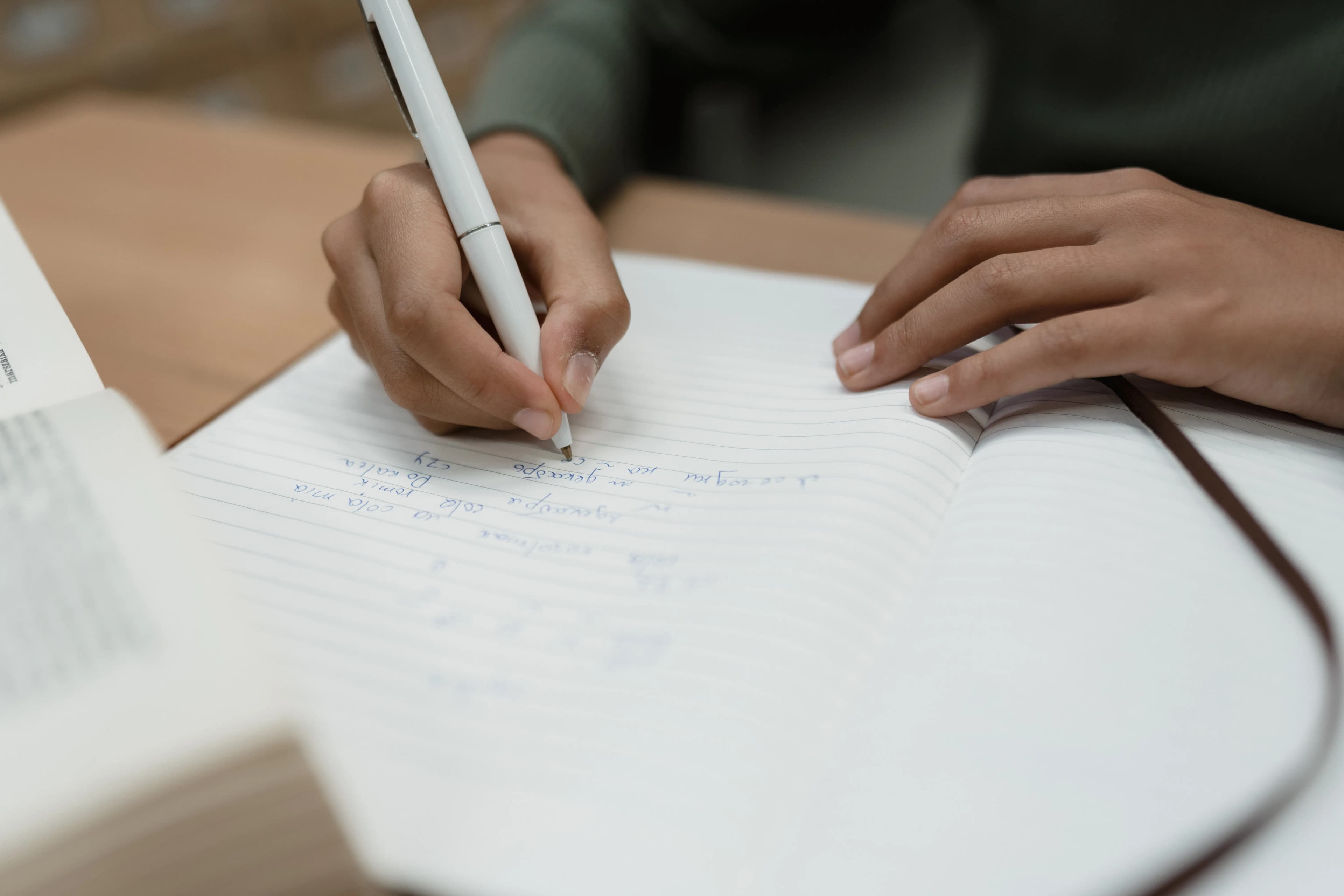 A person writing thoughtful notes in a notebook