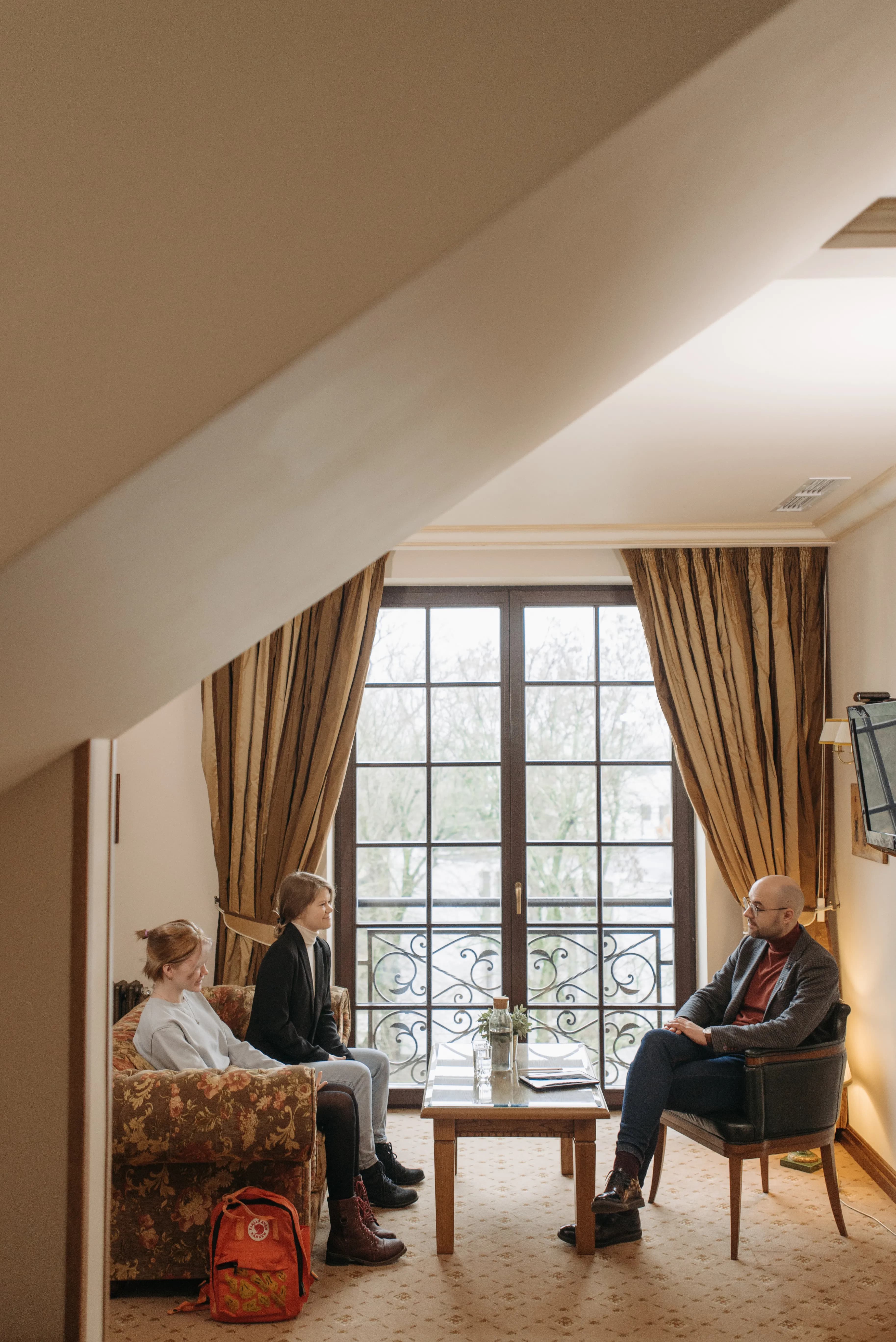 Adult speaking thoughtfully with teenagers on a sofa