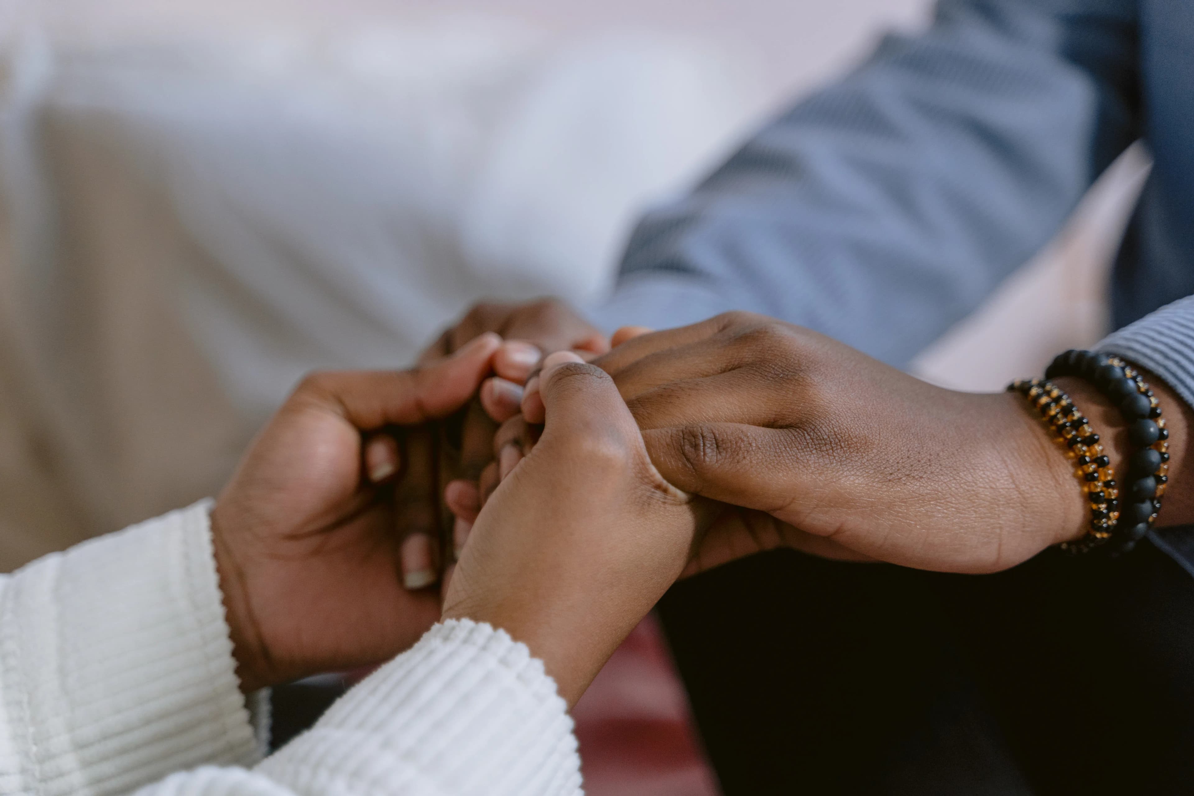 Close-up of hands held together as a gesture of mutual support