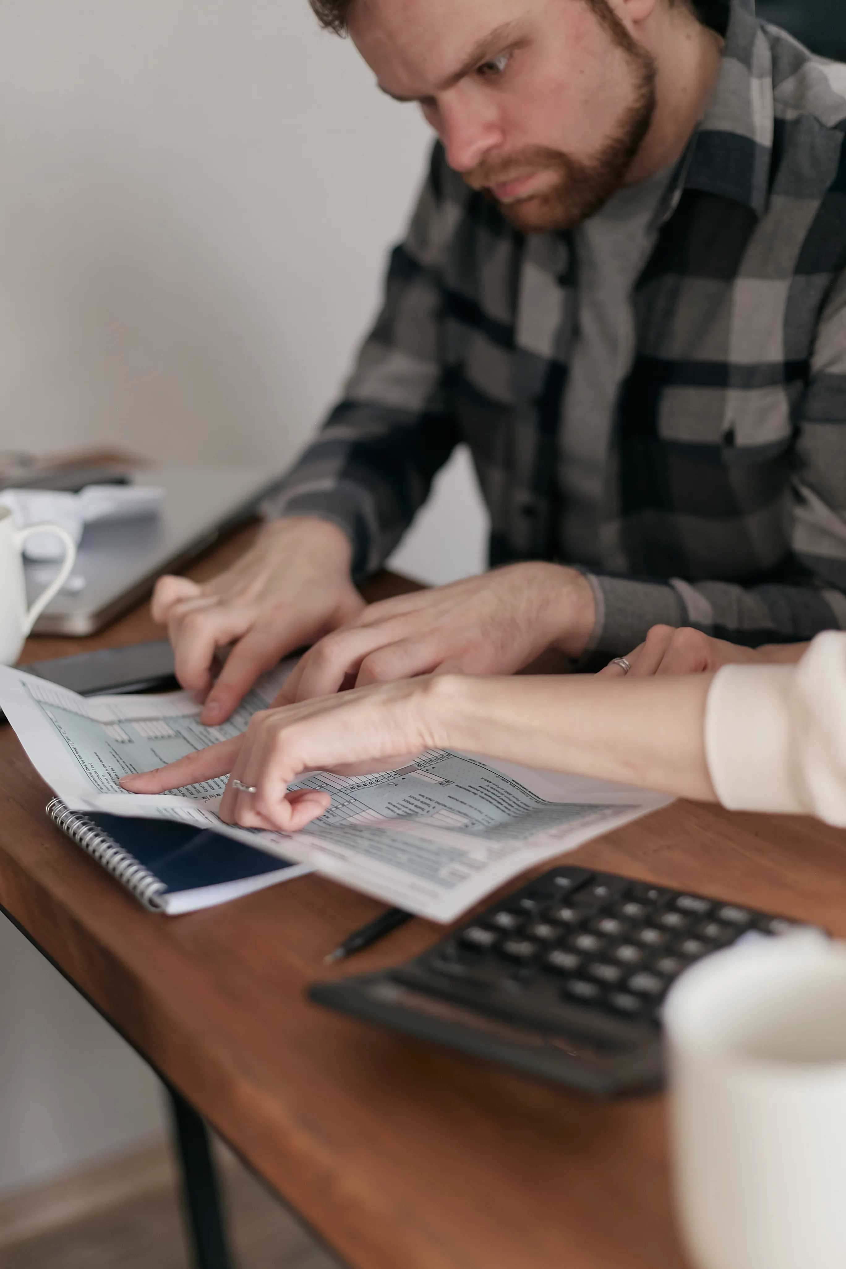 Adult couple examining paperwork together at a table