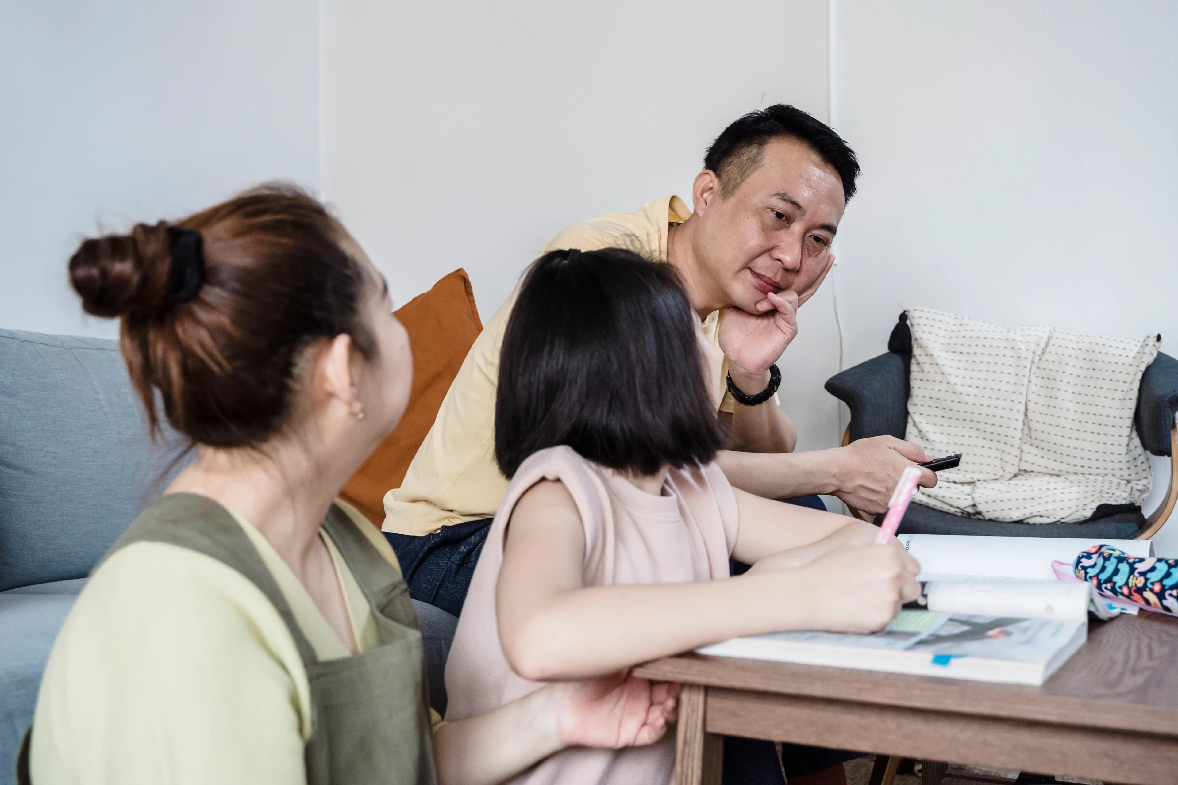 Parents supporting their child during homework at the table
