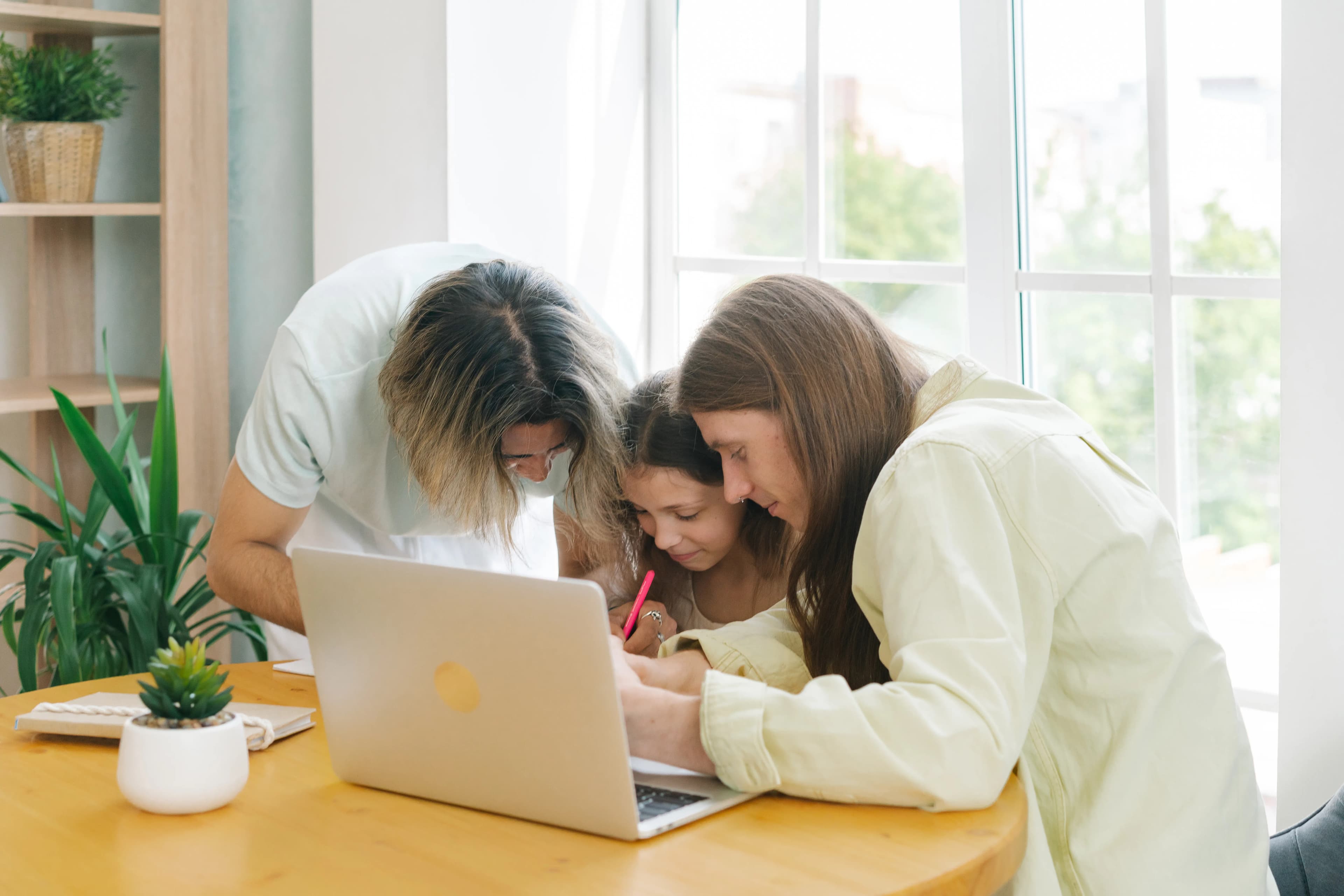 Parents helping a child with homework at the table