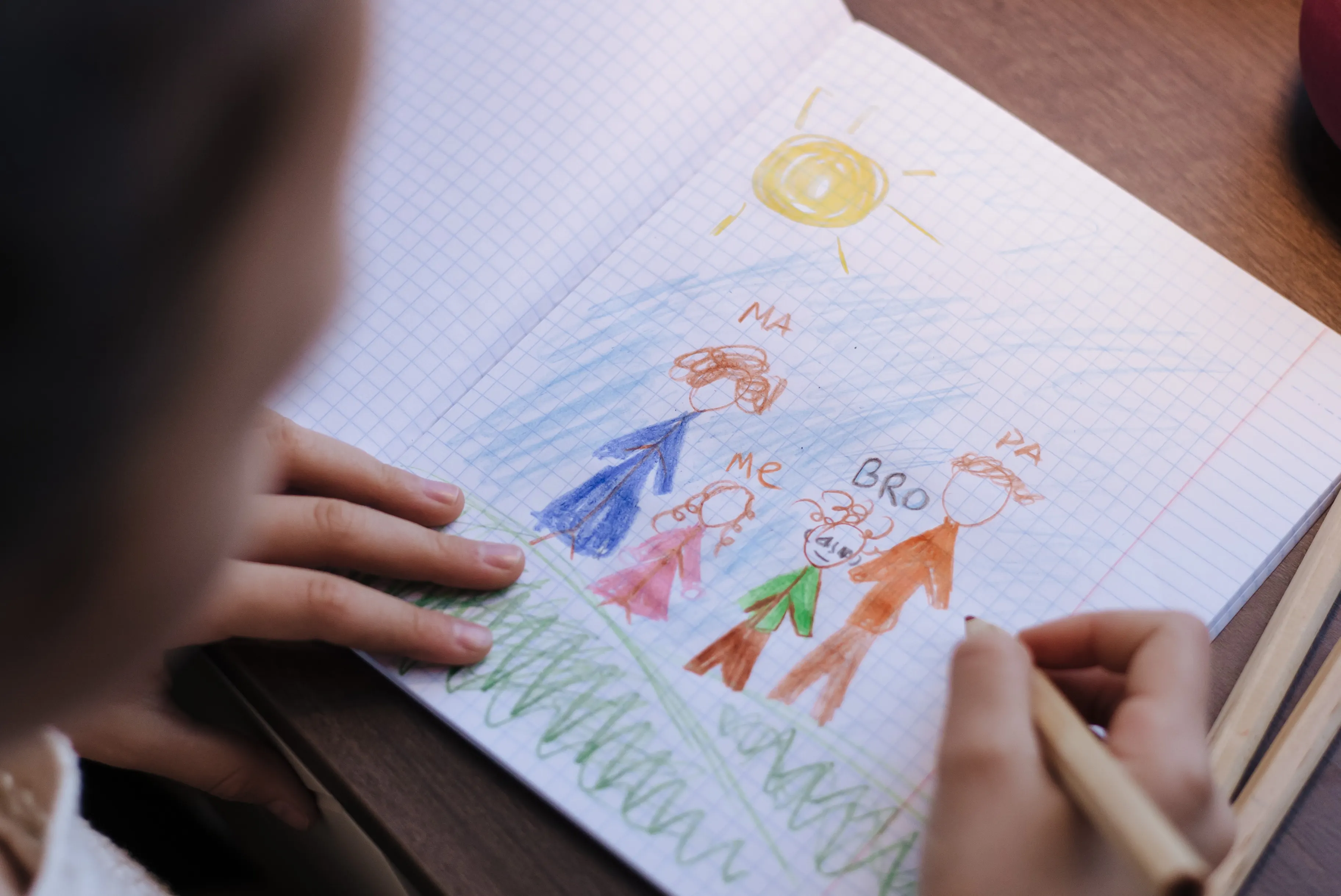A child's colourful drawing of a family on a tabletop
